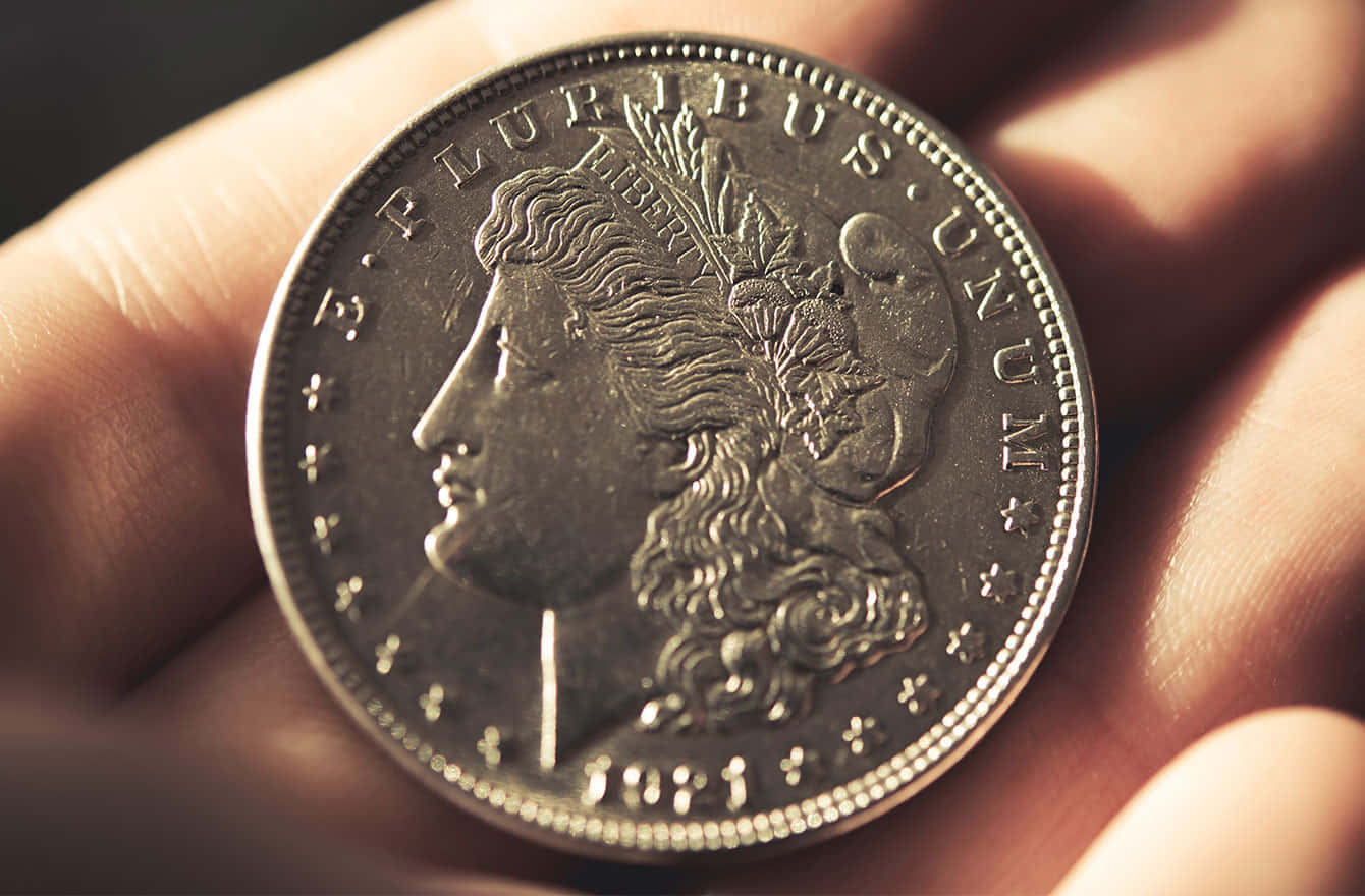 A Person Holding A Silver Morgan Dollar