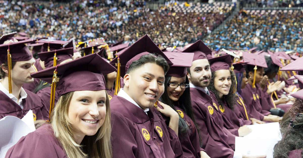 A Group Of Students In Maroon Graduation Gowns