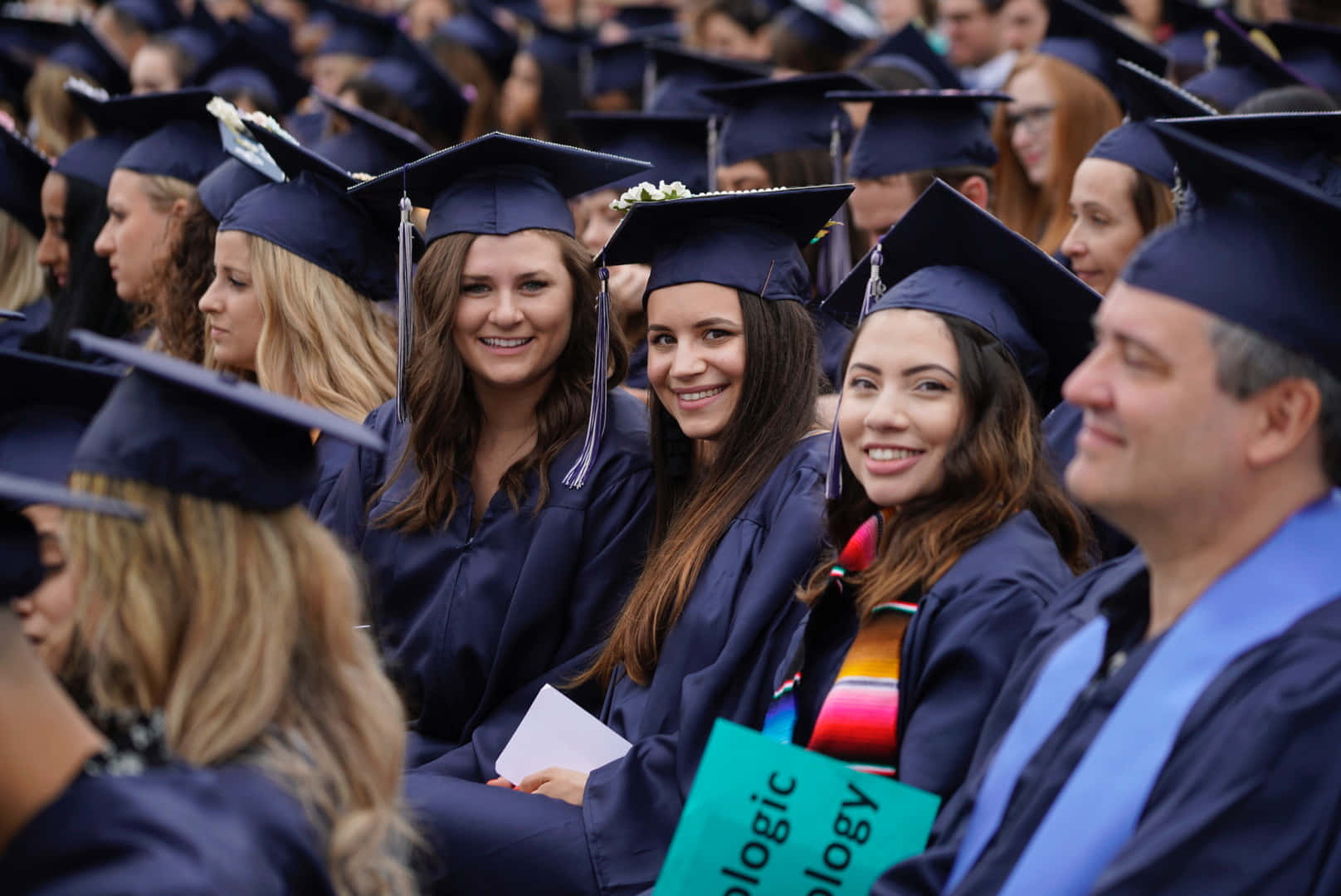 A Group Of Graduates Sitting In A Row
