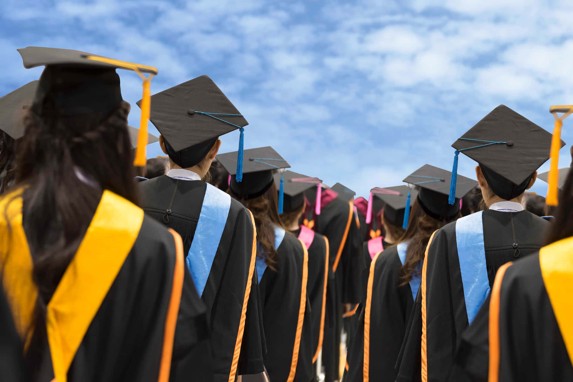 Premium  A young beautiful asian woman university graduate in graduation  gown and mortarboard holds a degree