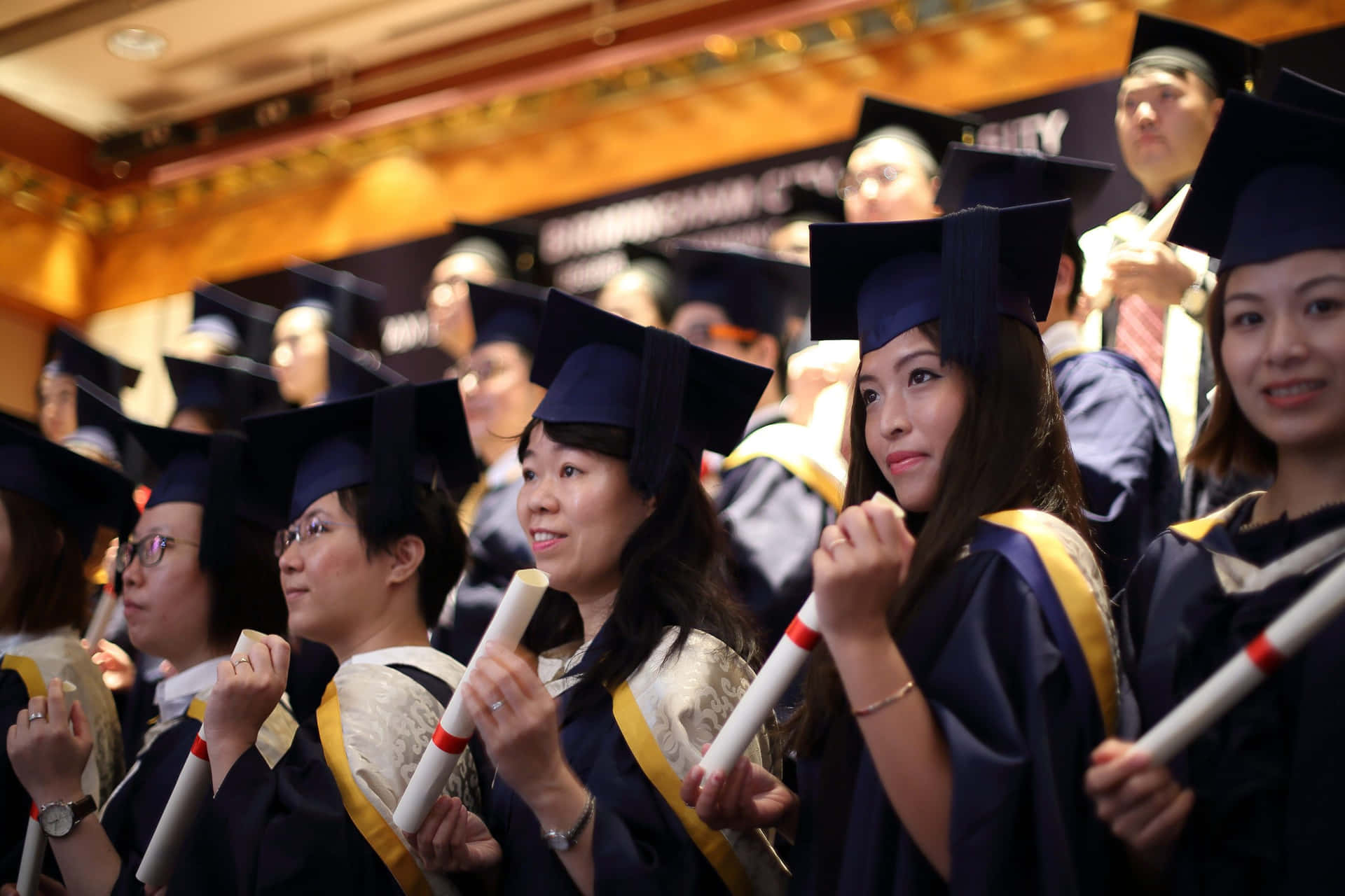 Estudiantessosteniendo Diplomas Enrollados Foto De Graduación Universitaria