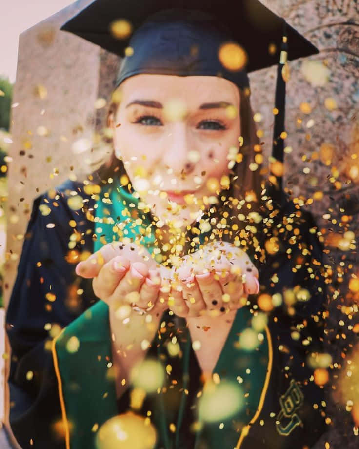 A Woman Blowing Confetti At A Graduation Ceremony