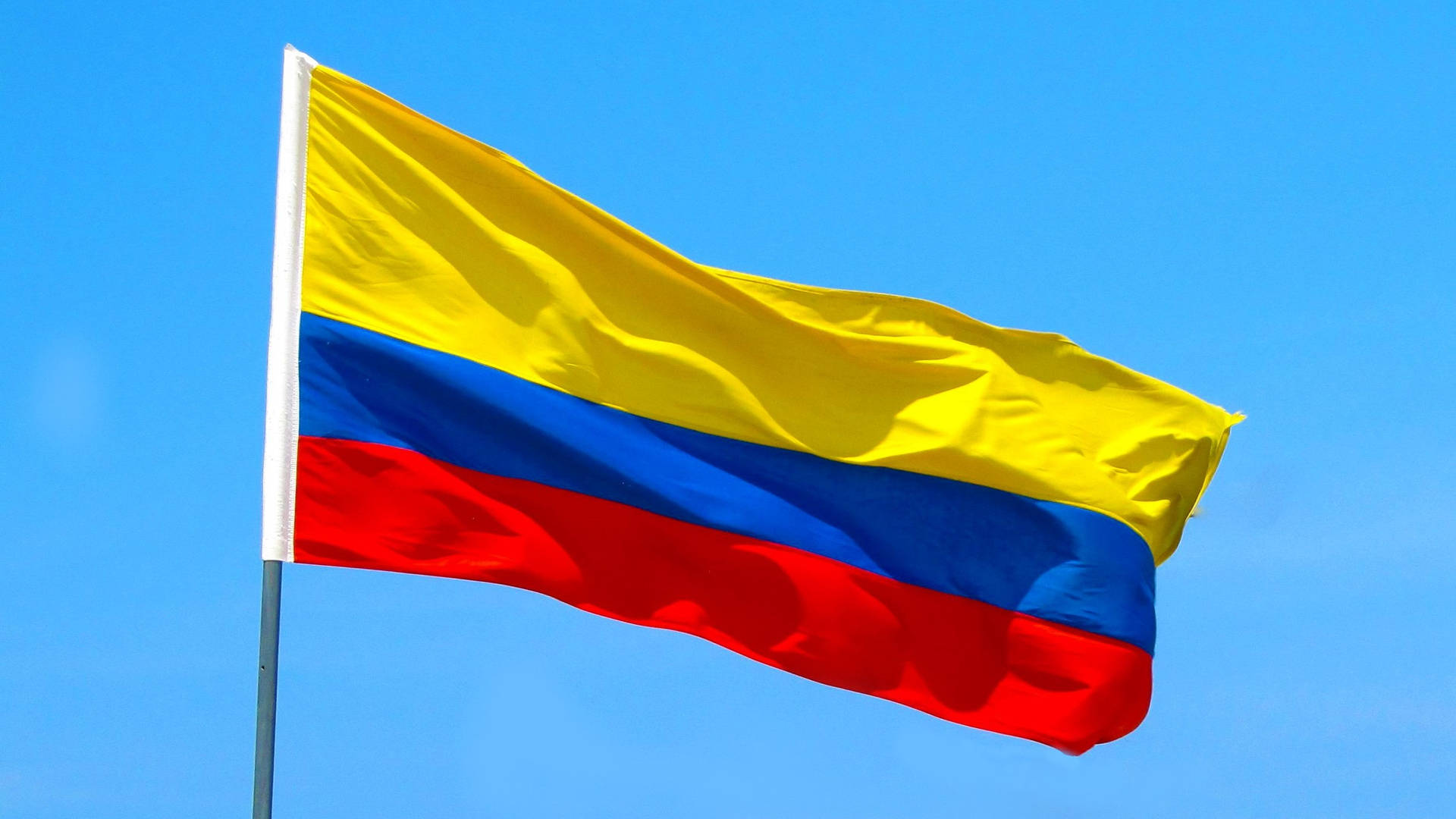 Kolumbianischeflagge In Der Luft Wallpaper