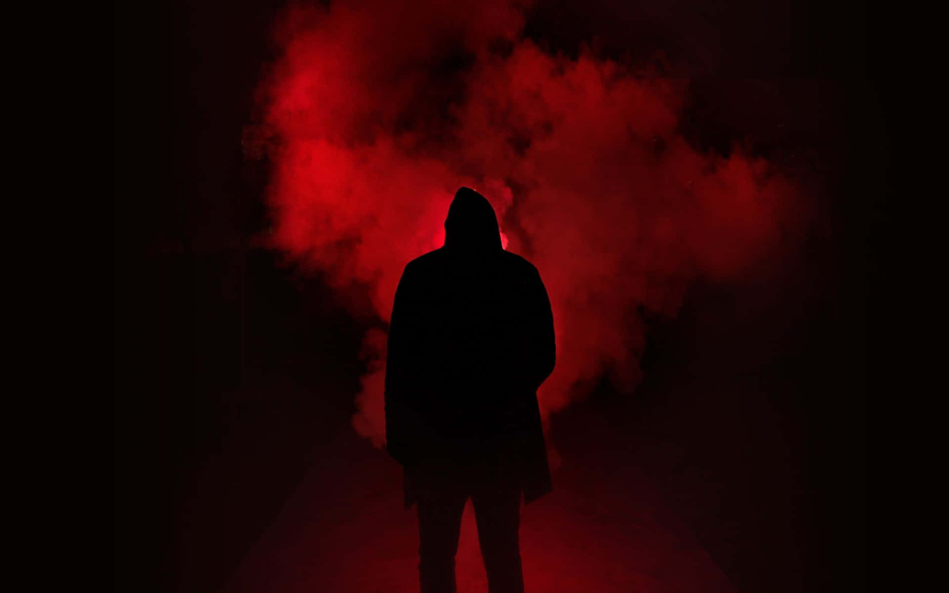 En silhuet af en person stående foran røg rød