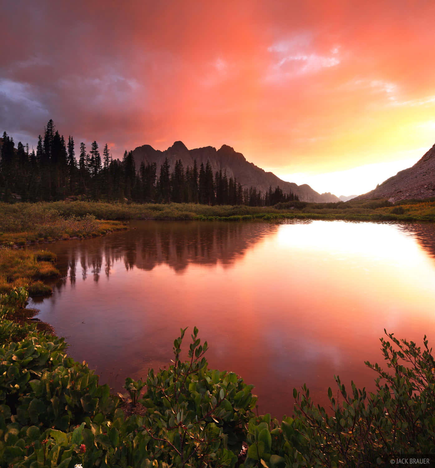 A Mountain Lake Is Reflected In The Sunset