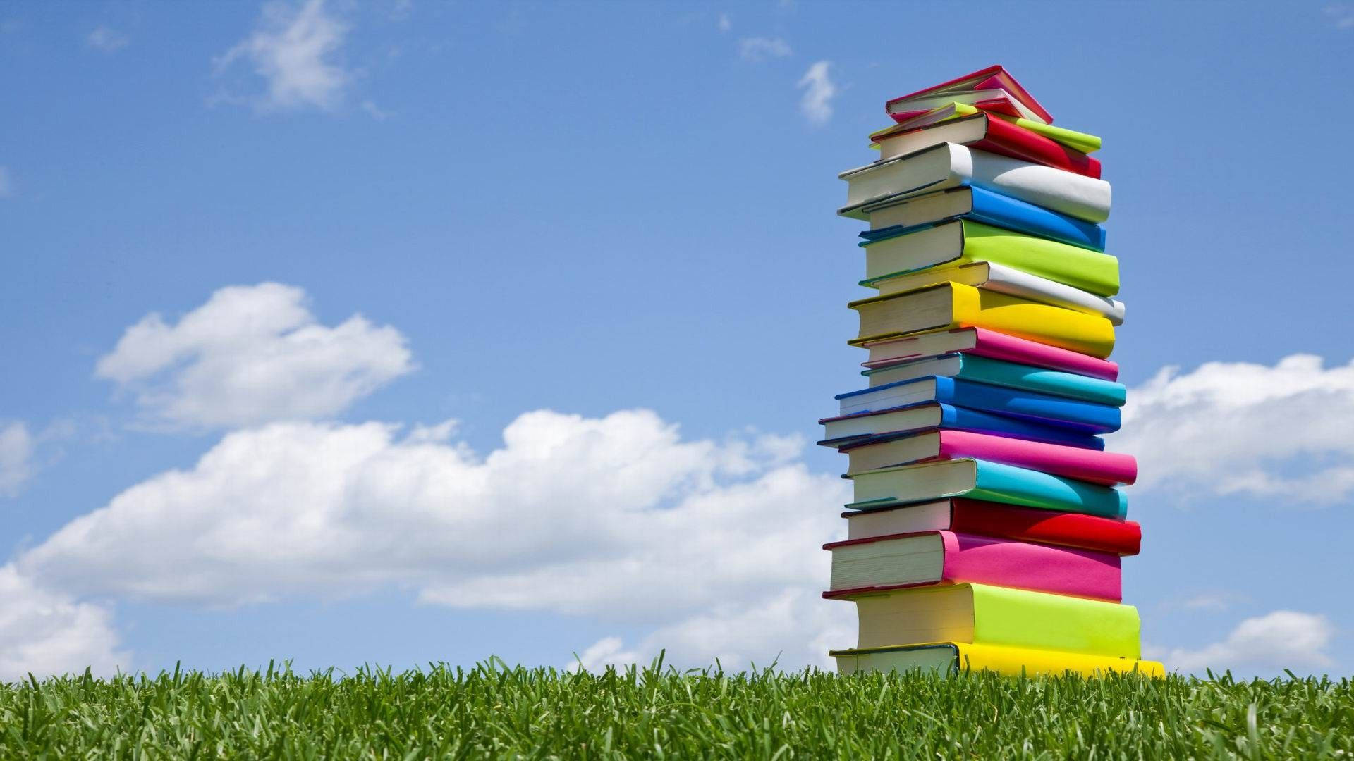 Colorful stack of books placed outside wallpaper