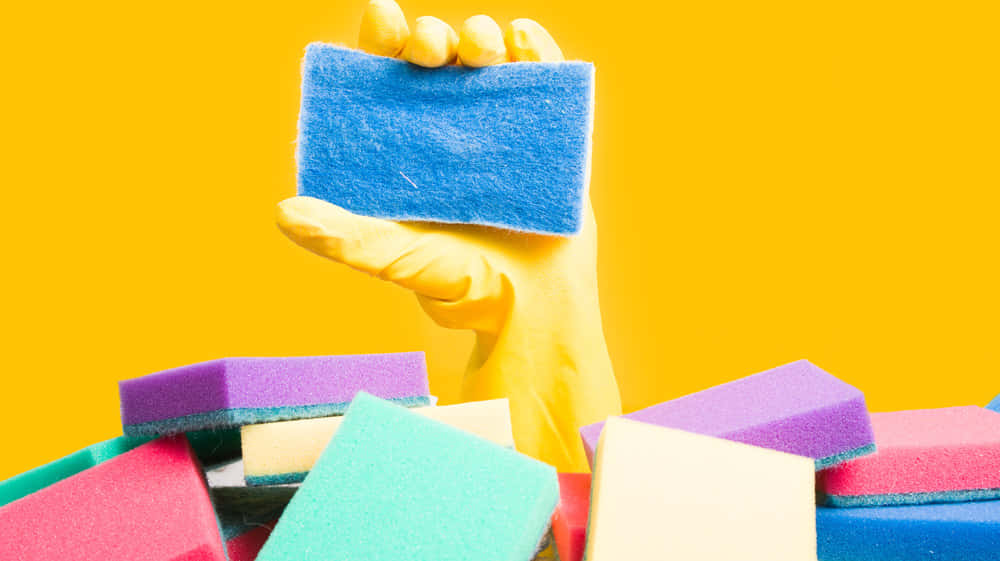 Colorful Cleaning Spongesand Gloved Hand Wallpaper