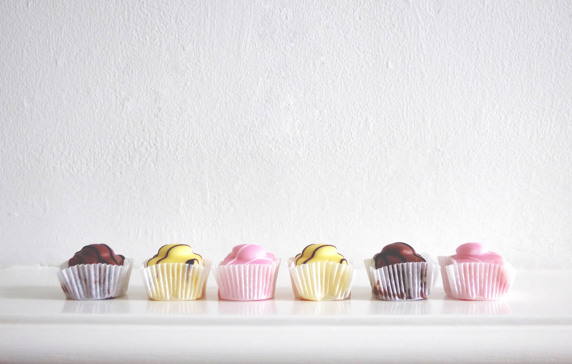 Colorful Cupcakes On White Background Wallpaper