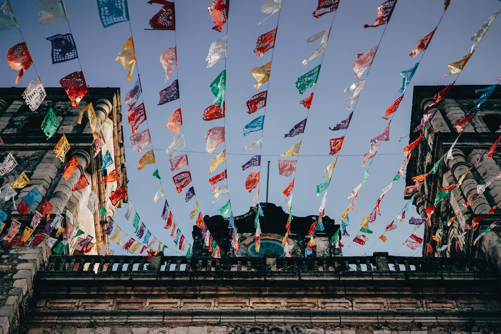 Colorful Fiesta Banners Against Blue Sky Wallpaper