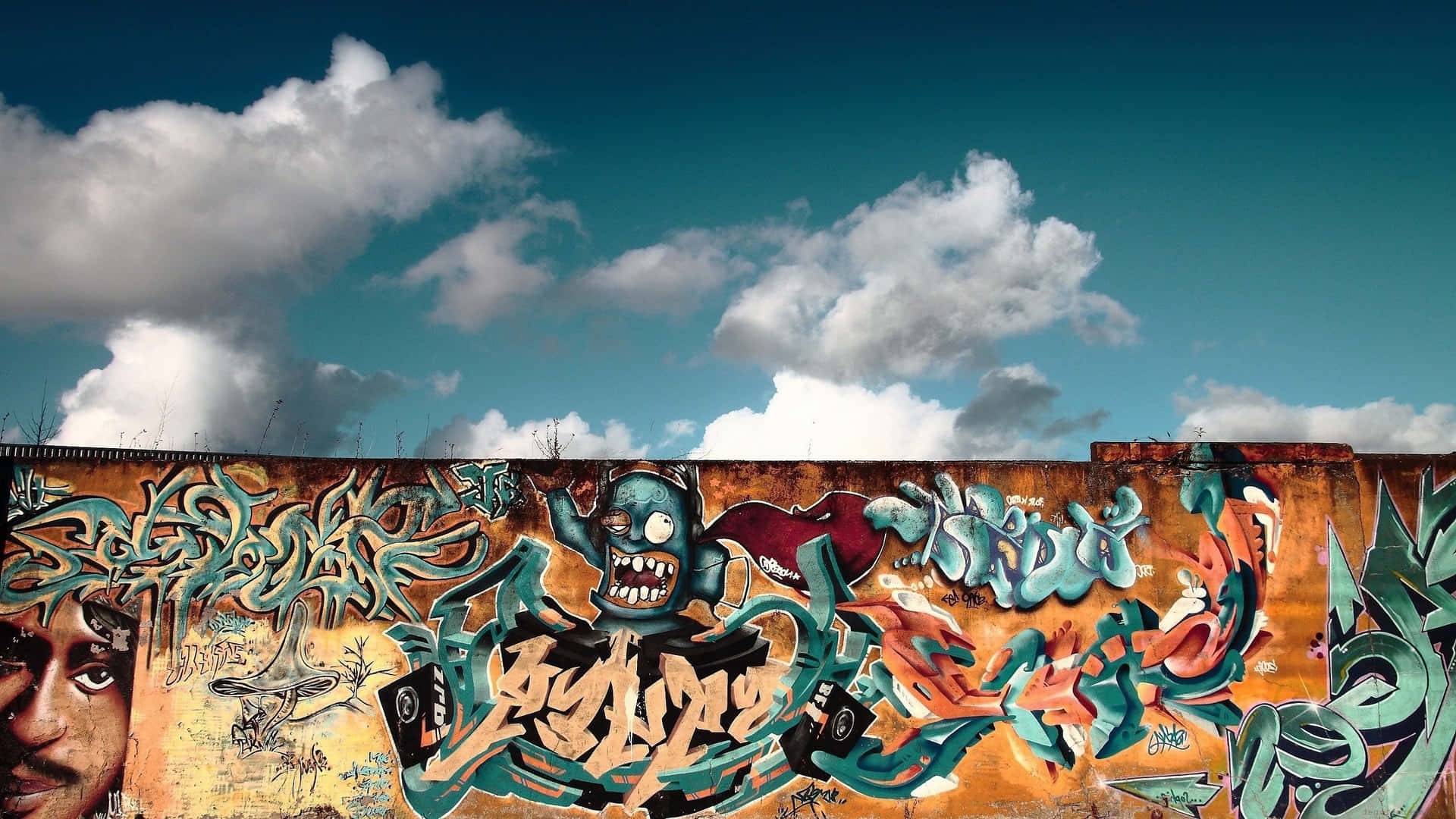 Colorful Graffiti Mural On Berlin Wall And Blue Skies Background