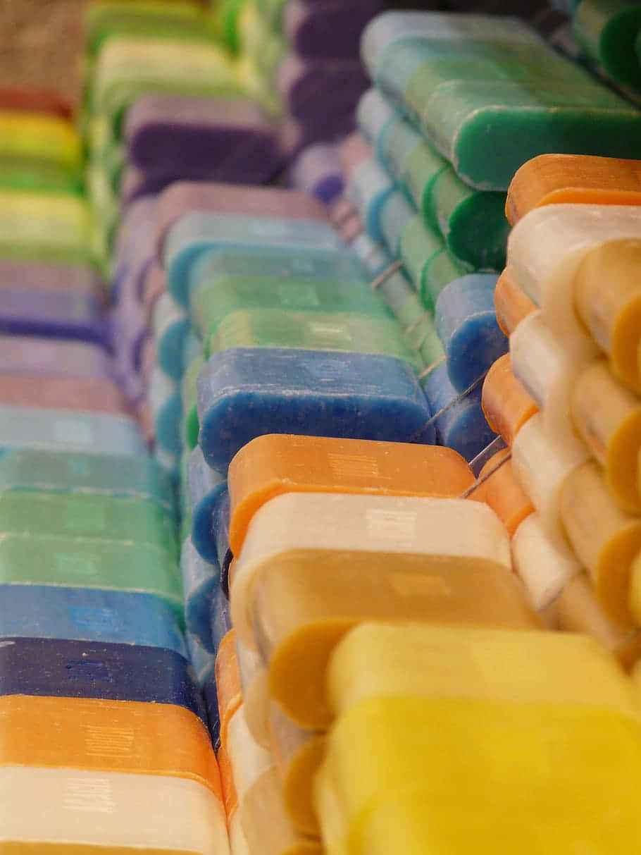 Variety of vibrant handmade soaps lined up neatly. Wallpaper