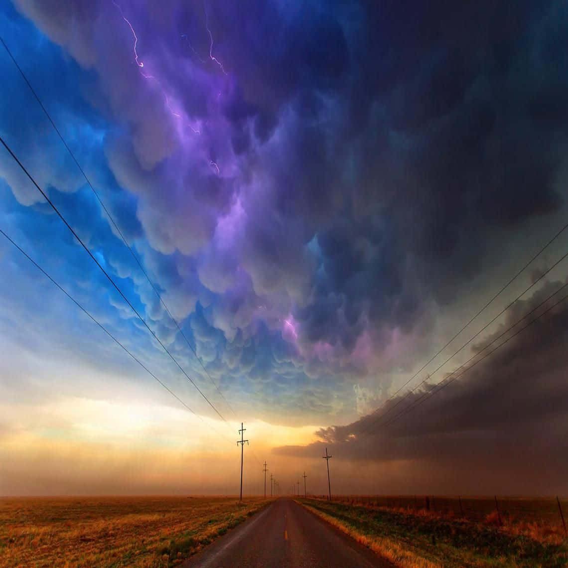 Download Lightning Over A Road With Power Lines | Wallpapers.com