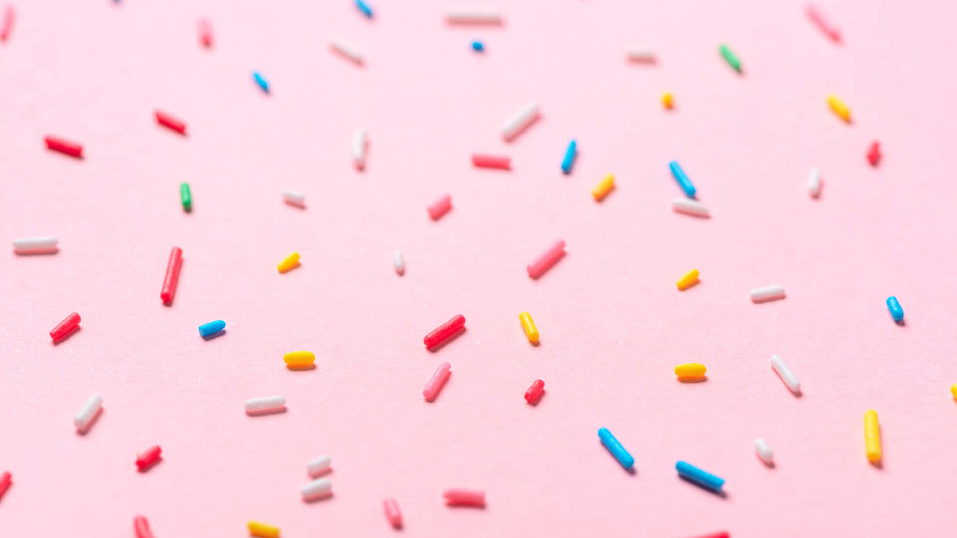 Colorful Sprinkleson Pink Background Wallpaper