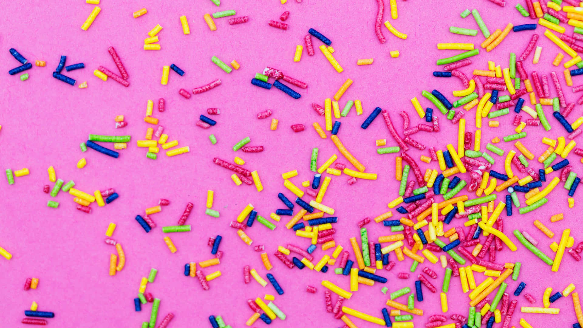 Colorful Sprinkleson Pink Background Wallpaper