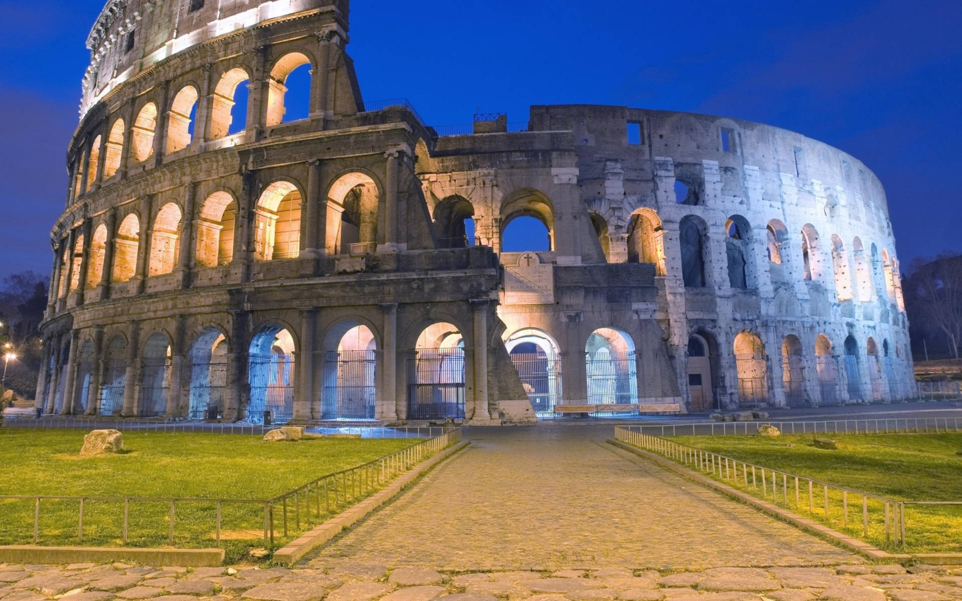Colosseum om natten med tændte buer. Wallpaper