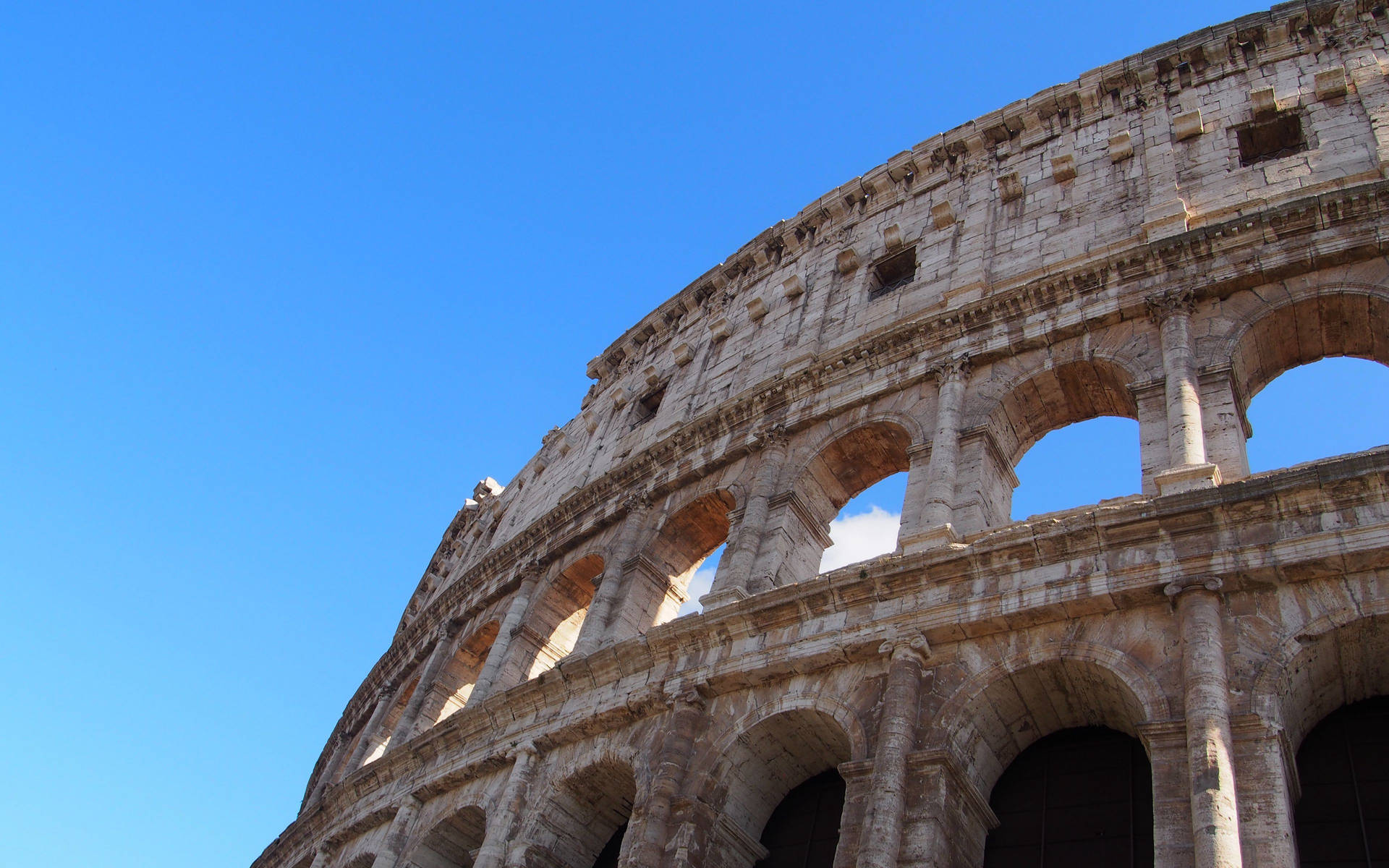Bakgrundsbildpå Datorskärmen: Colosseum Som Blickar Mot Klarblå Himmel. Wallpaper