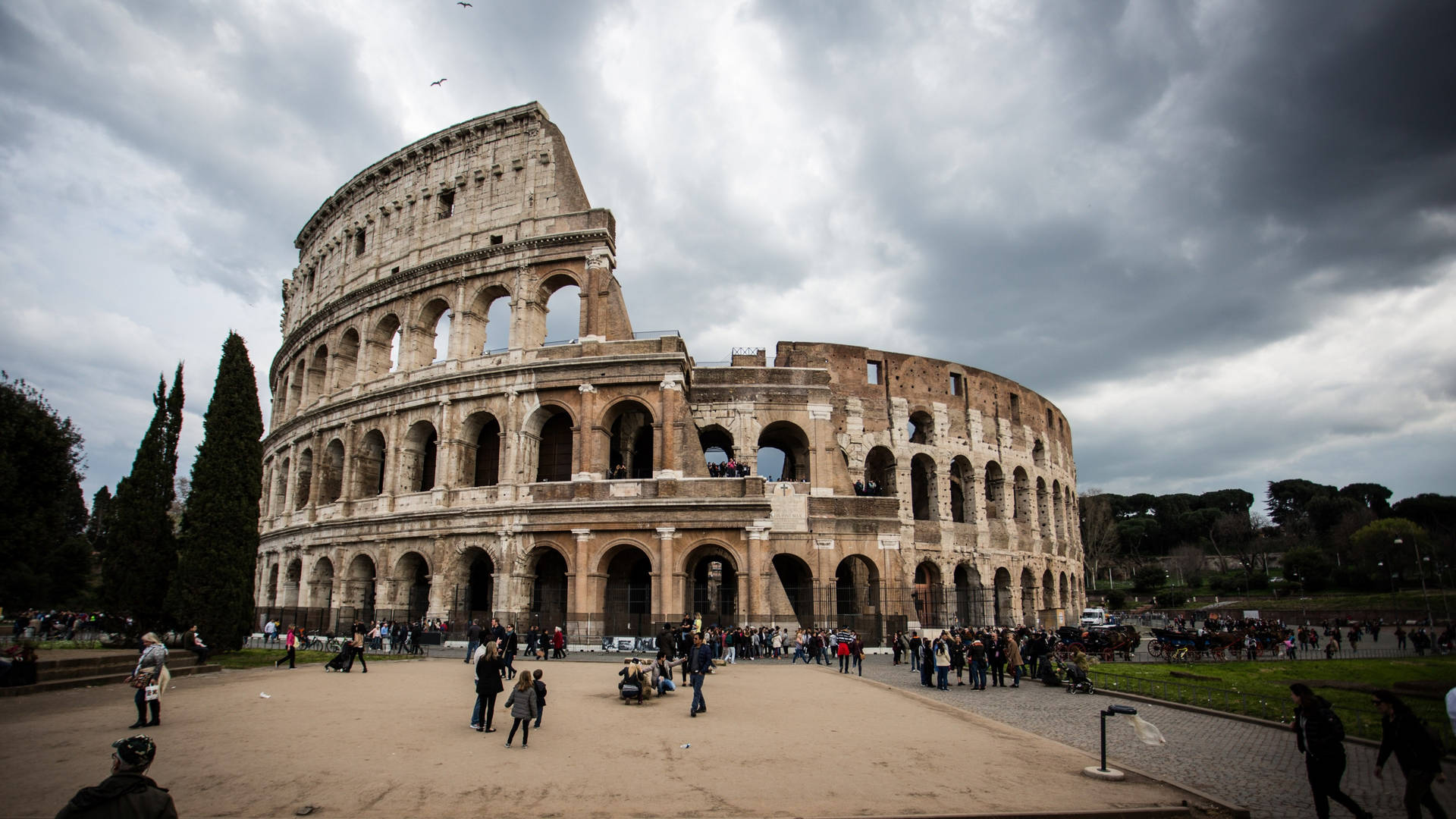 Colosseum In Rome Beneath The Cloudy Sky Wallpaper