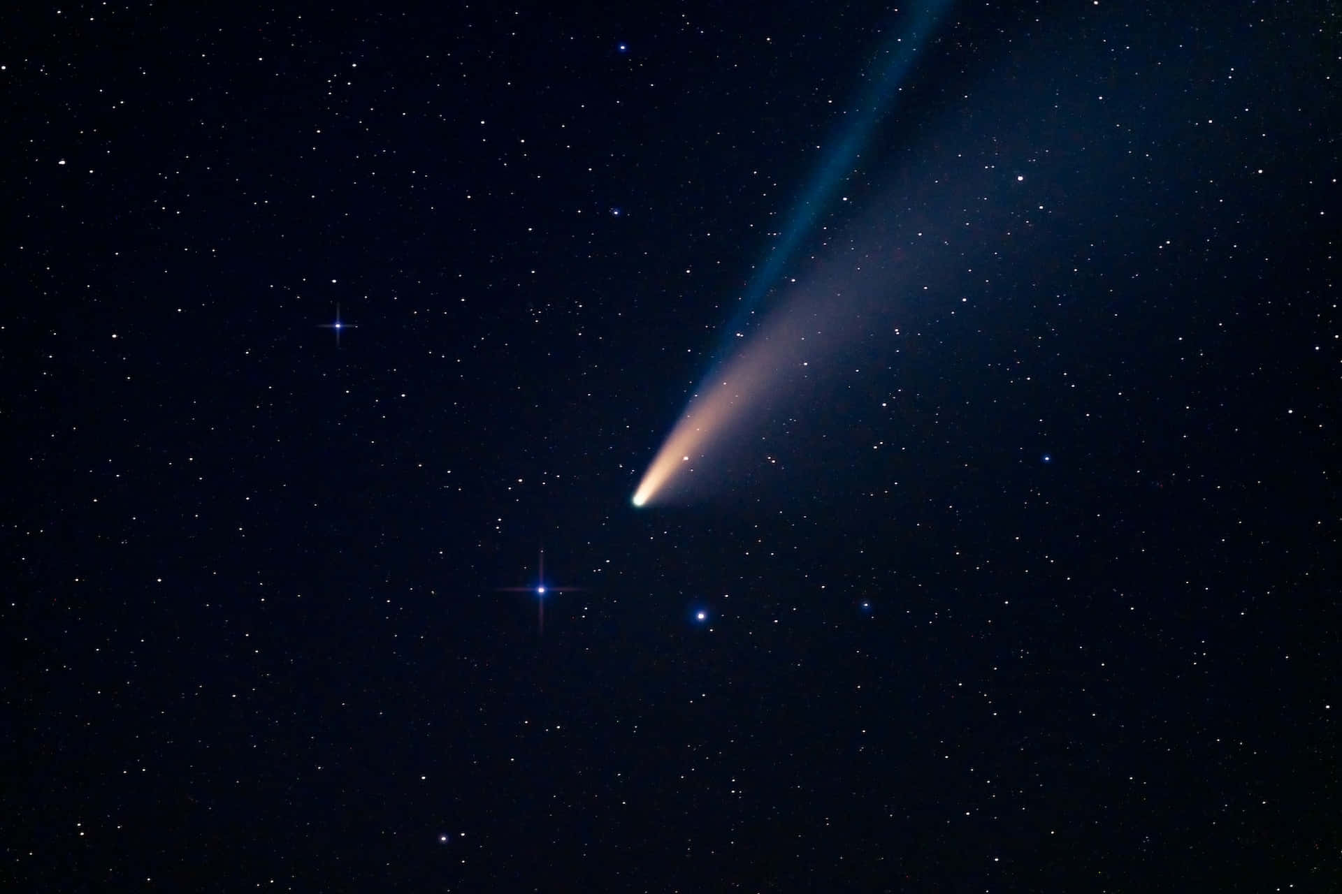 A dazzling comet streaks across the night sky Wallpaper