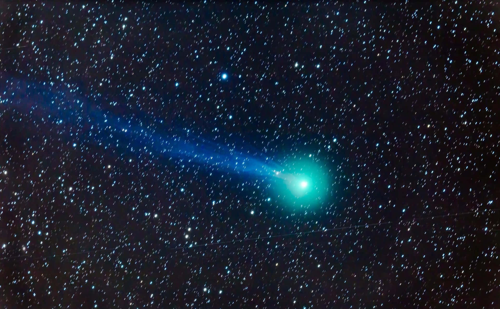A bright comet streaking across the night sky Wallpaper