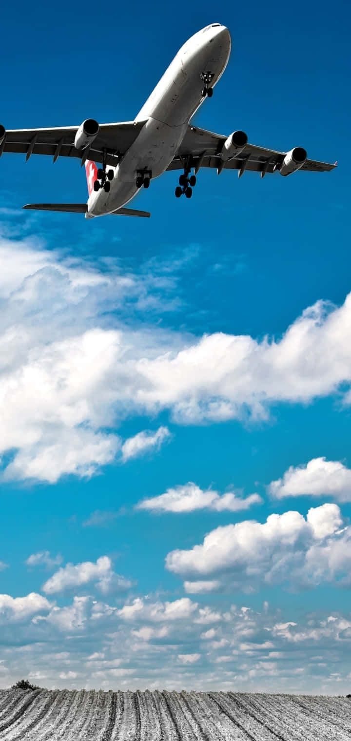 Commercial Airplane Ascending Above Clouds Wallpaper