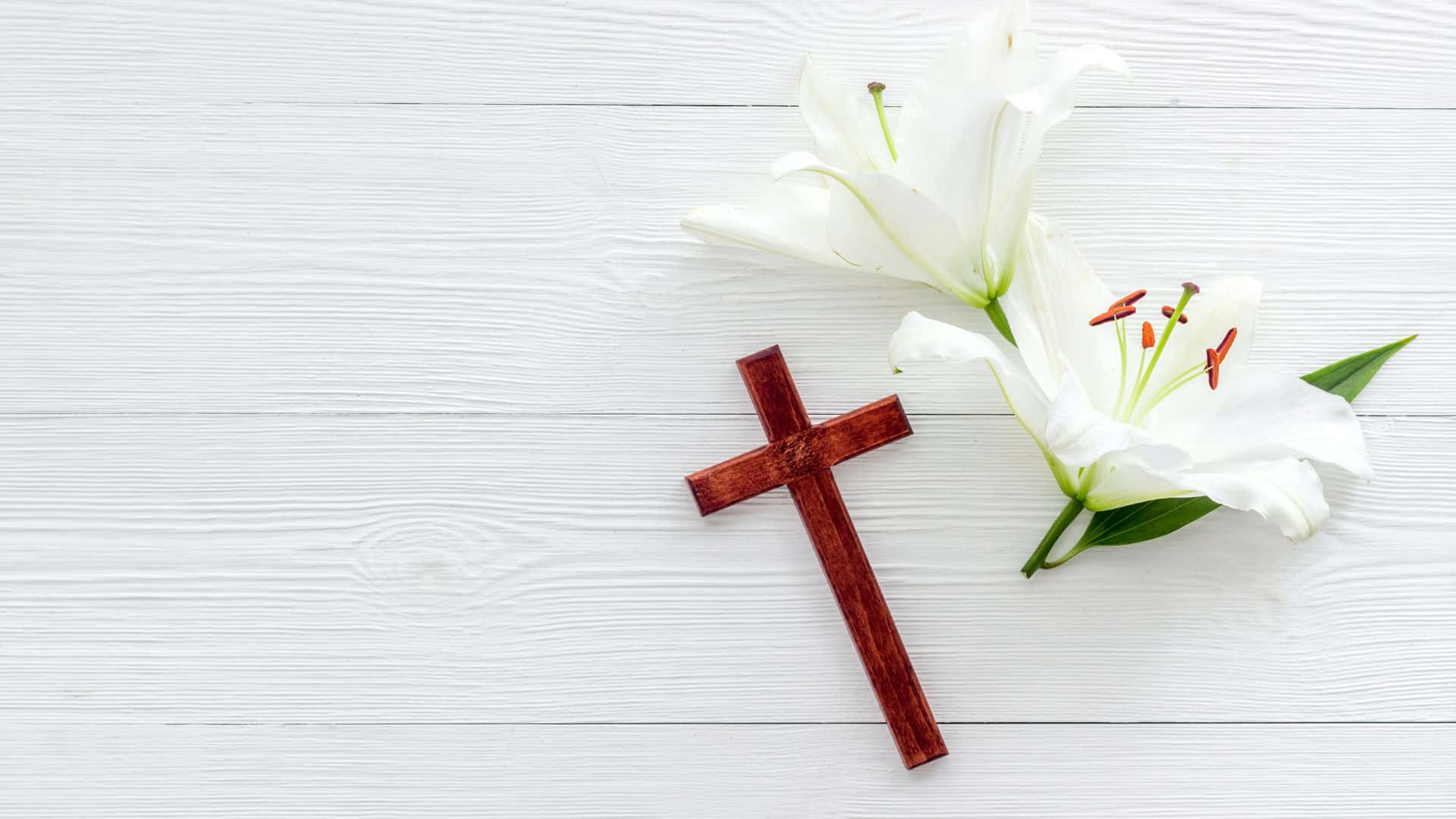 White Lilies And A Cross On A White Wooden Table