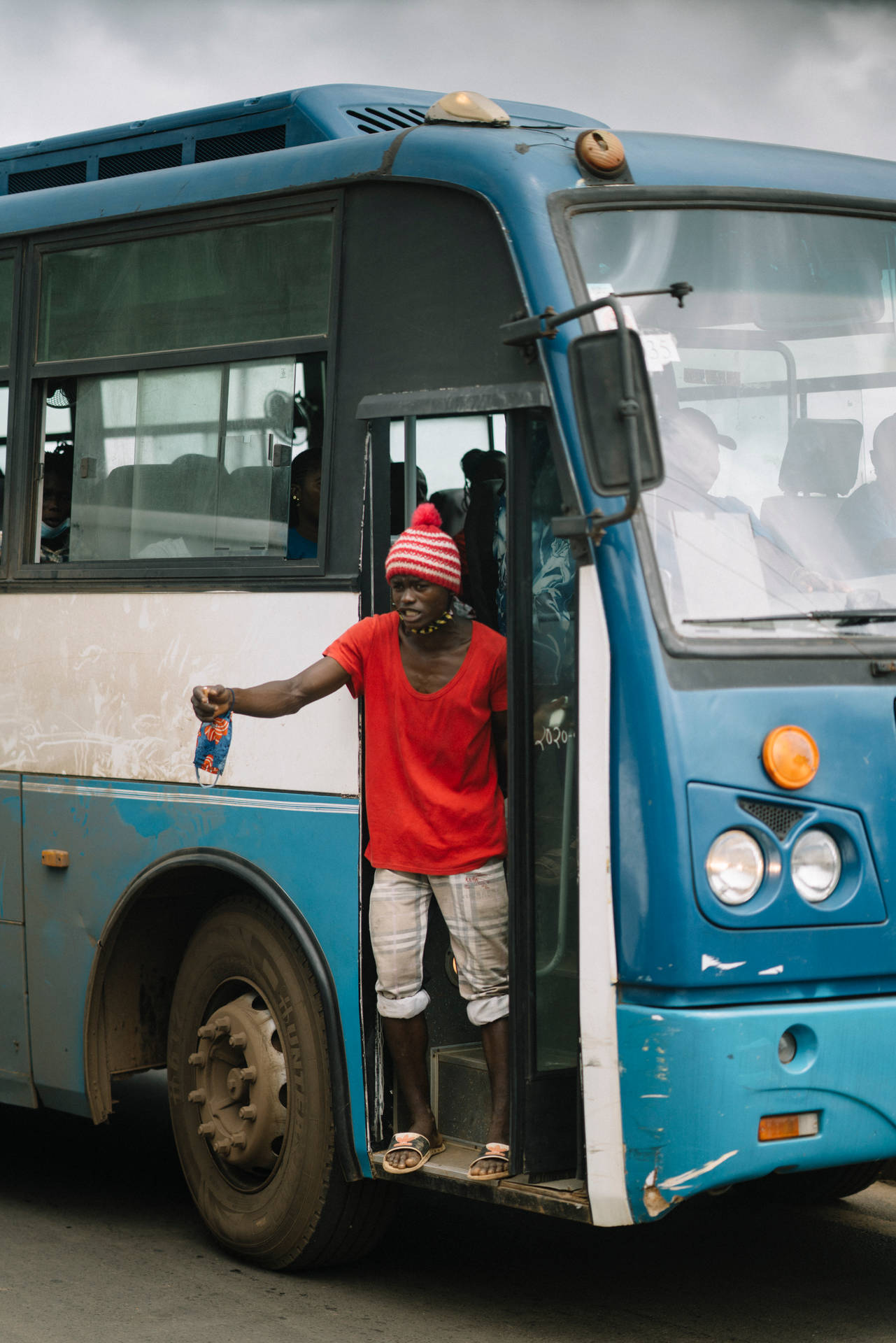 Conductor By The Bus Door In Sierra Leone
