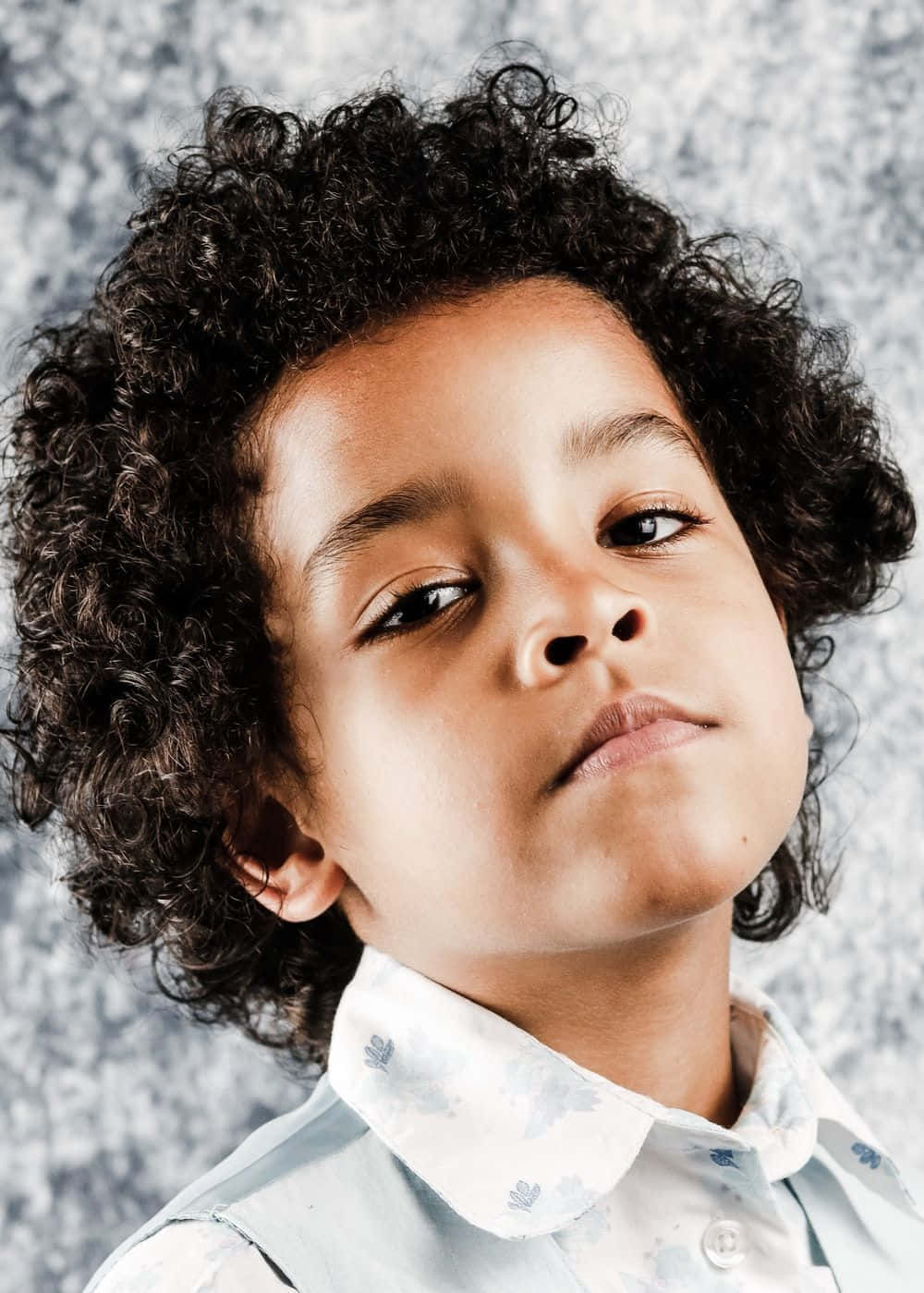 Confident Young Boywith Curly Hair Wallpaper