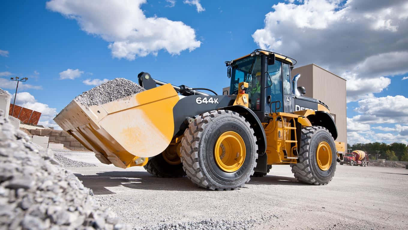 A Large Yellow Wheel Loader Is Parked On A Gravel Road