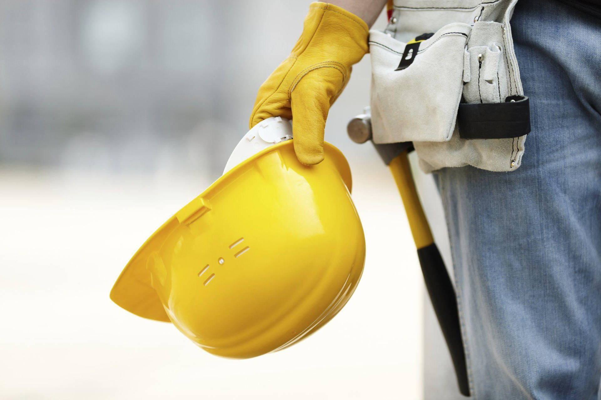 Construction Worker's Hand Holding A Hard Hat Wallpaper