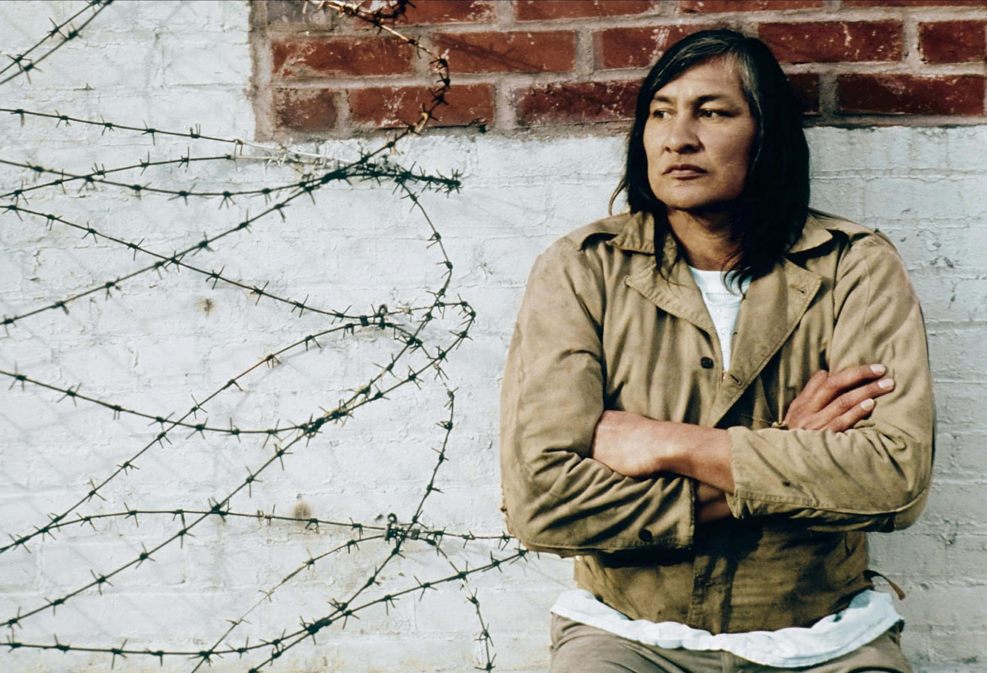 Contemplative Man Against Brick Wall Wallpaper