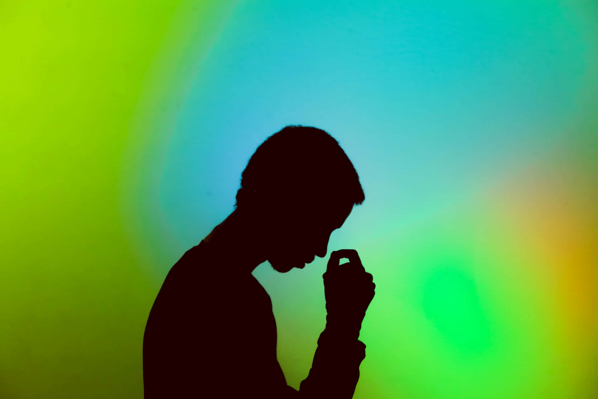 Contemplative Silhouette Against Colorful Backdrop.jpg Wallpaper