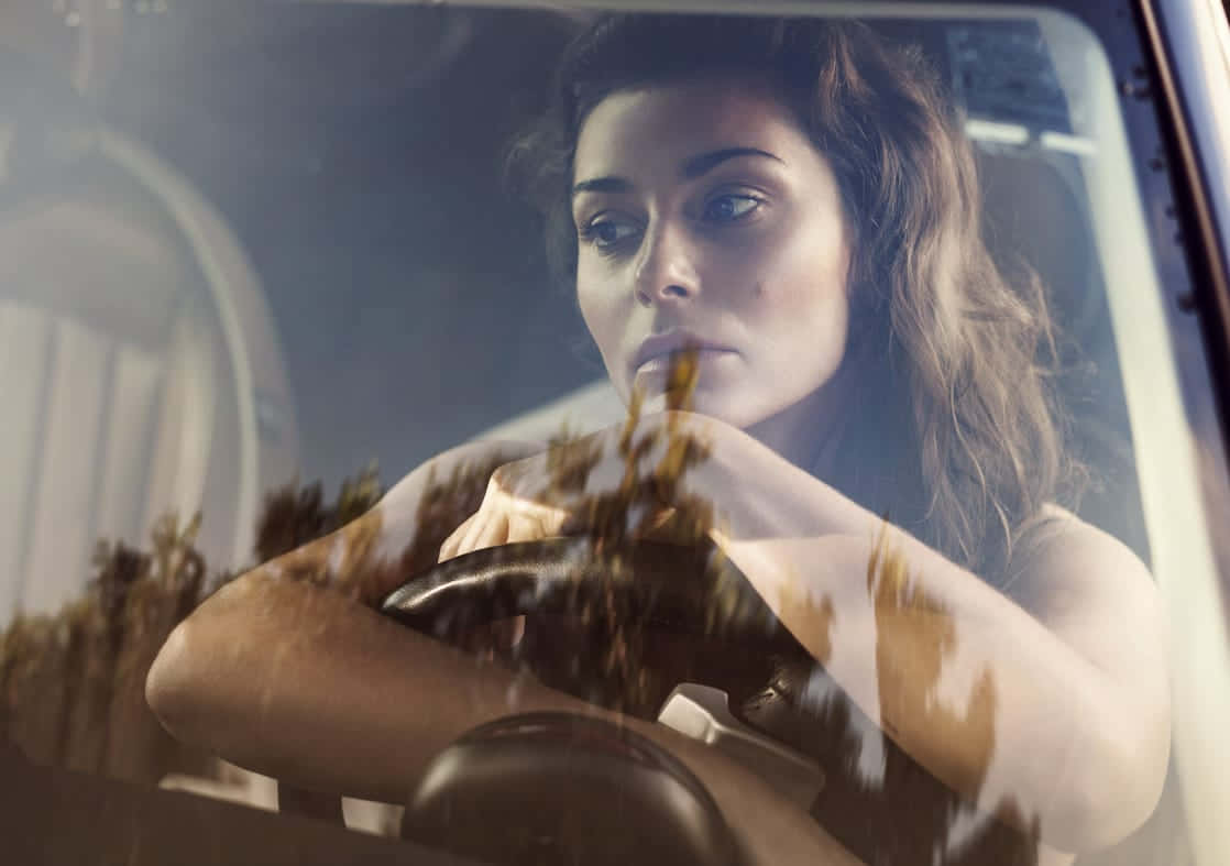 Contemplative Woman Driving Car Wallpaper