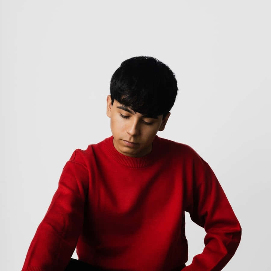 Contemplative Young Manin Red Sweater Wallpaper