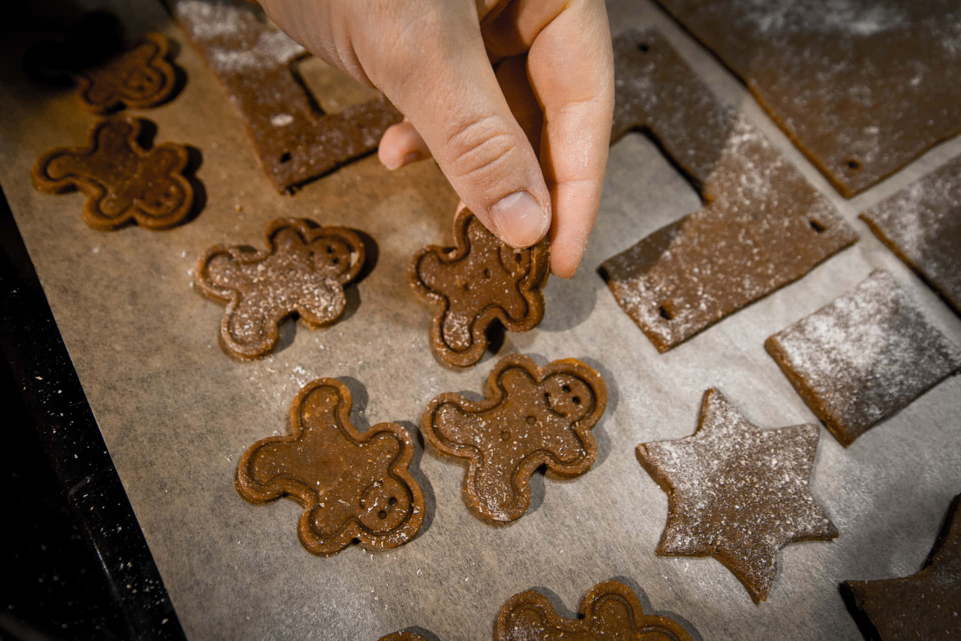 A Person Is Putting Some Gingerbread Cookies On A Baking Sheet