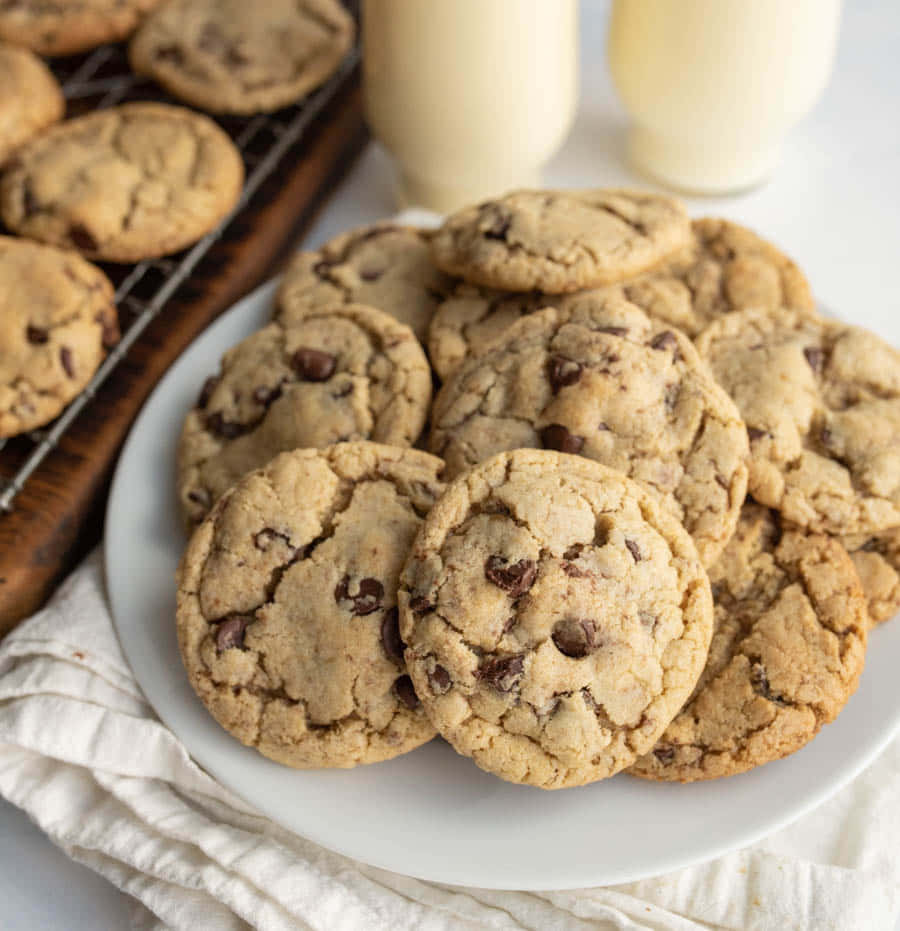 A Plate Of Chocolate Chip Cookies With Milk