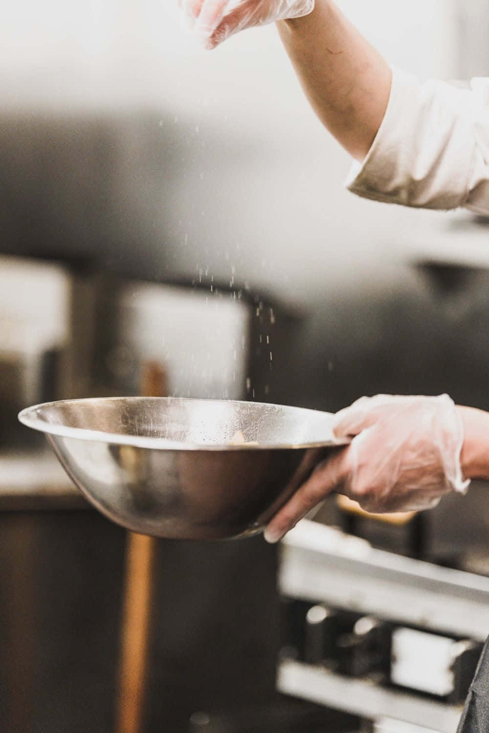 A Chef Pouring A Bowl Of Flour Into A Pan