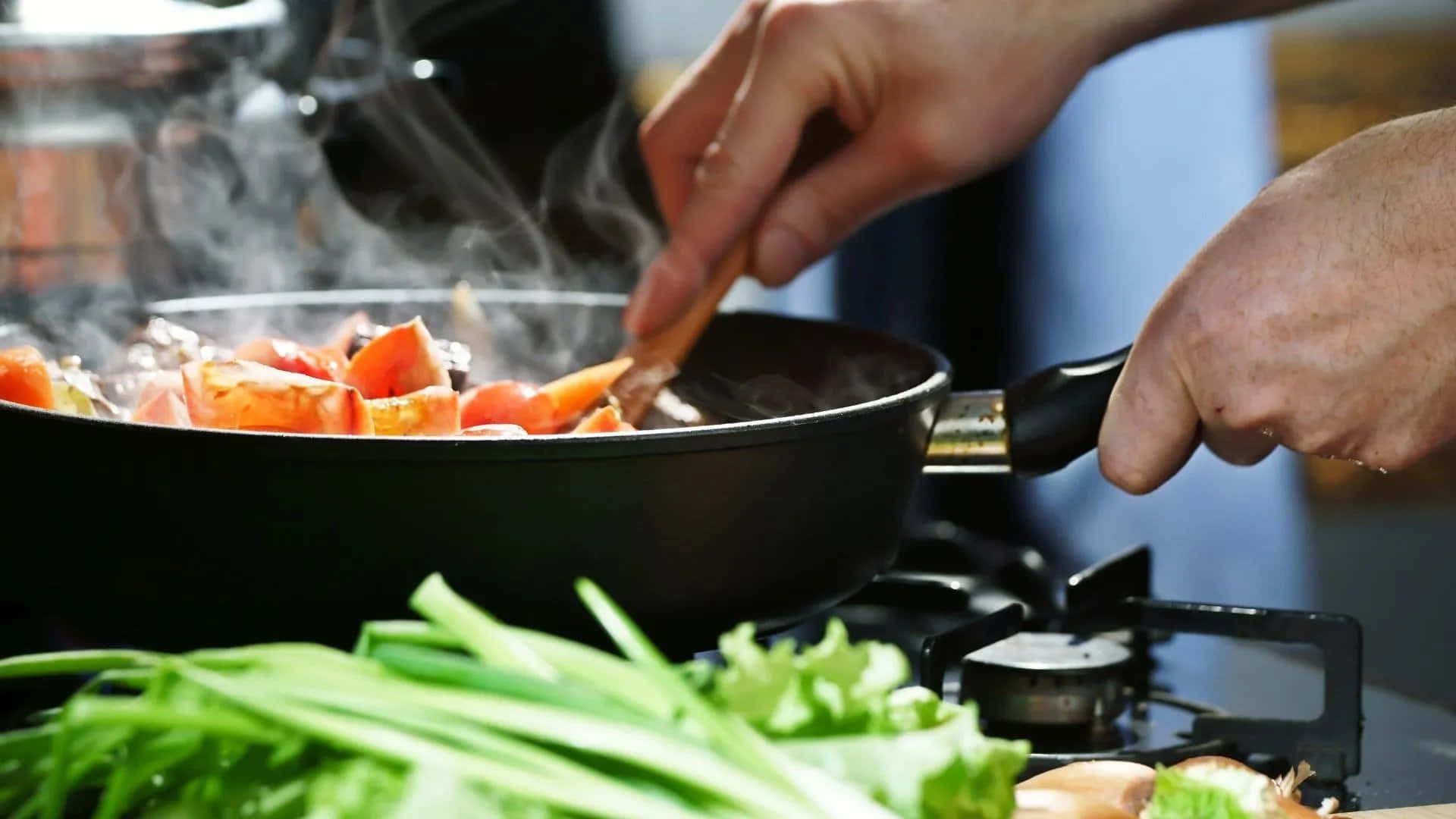 A Person Is Cooking Vegetables In A Pan
