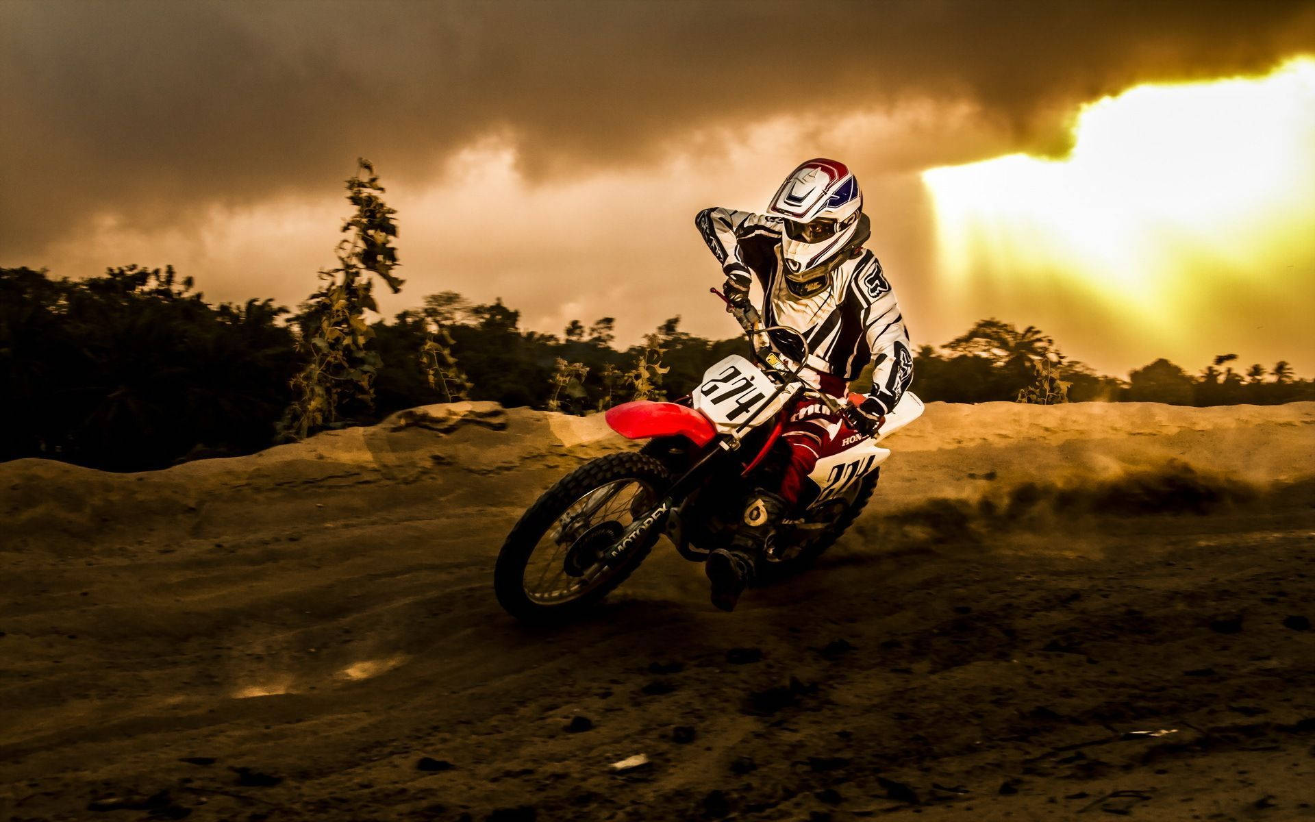 Unpiloto De Motocross Está Conduciendo Su Moto Por Un Campo De Tierra. Fondo de pantalla