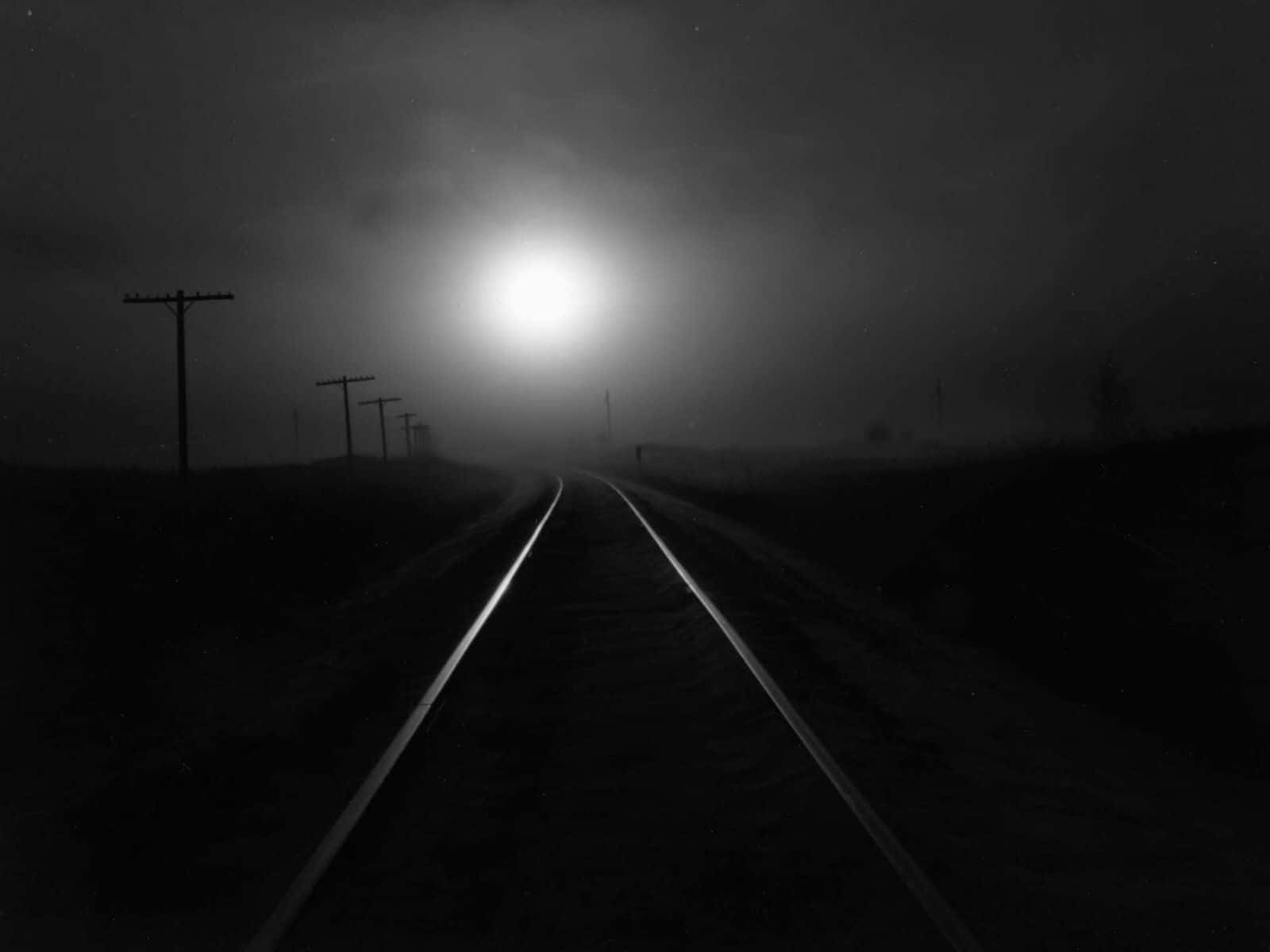A Black And White Photo Of A Train Track In The Fog Wallpaper