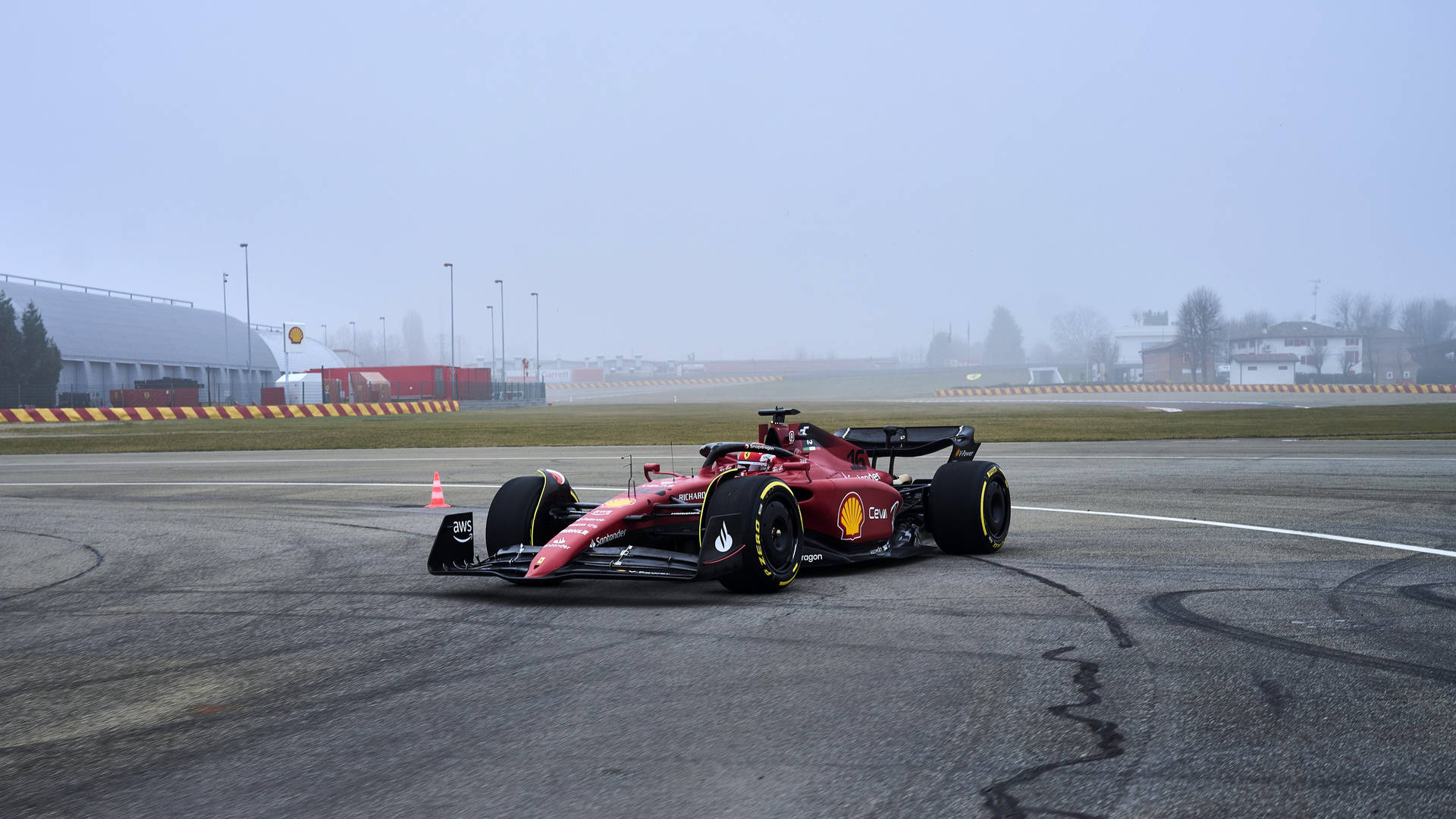 En Ferrari F1 kører på en bane i tågen Wallpaper