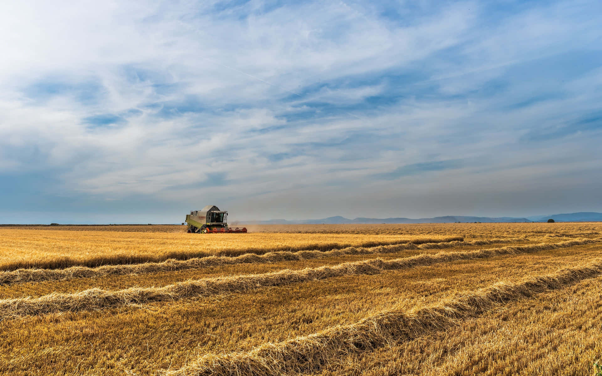 A Combine Harvester In A Field Wallpaper