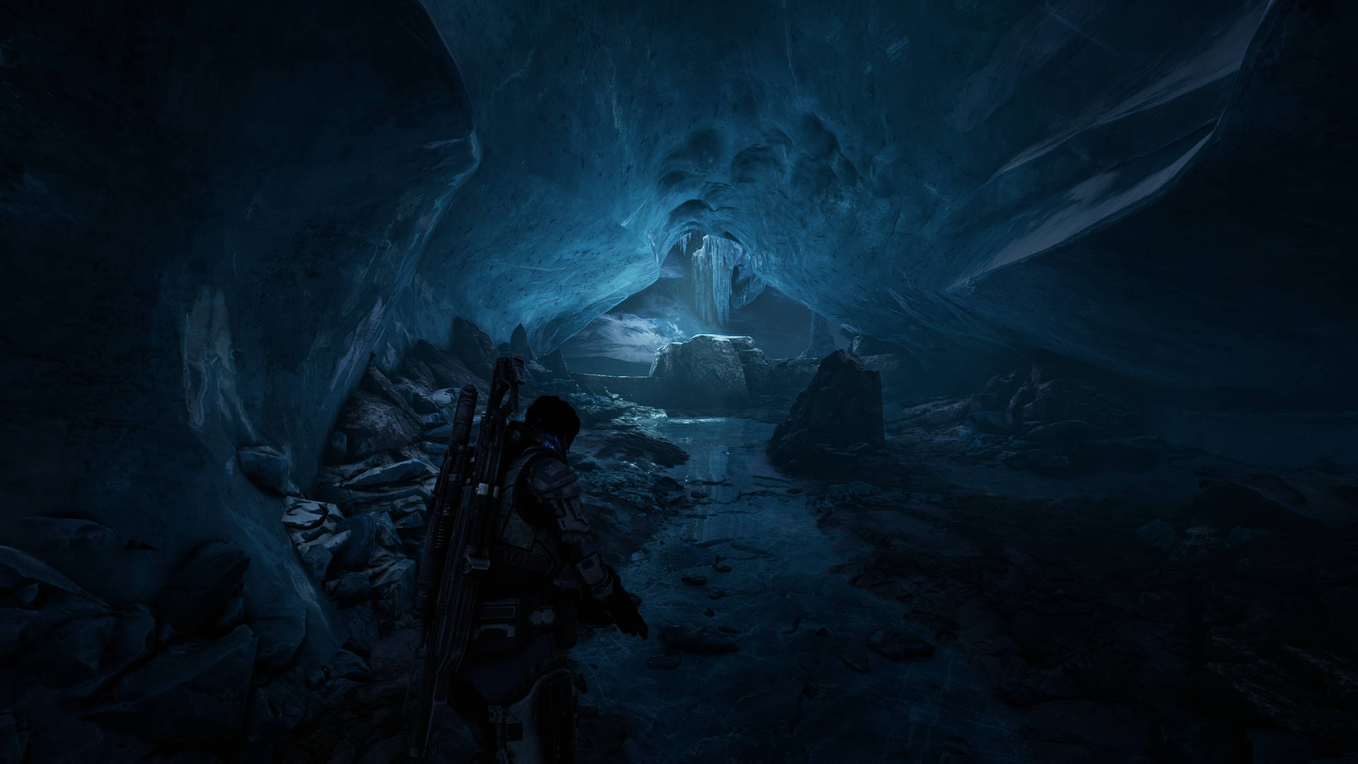 A Man Is Walking Through An Icy Cave Wallpaper