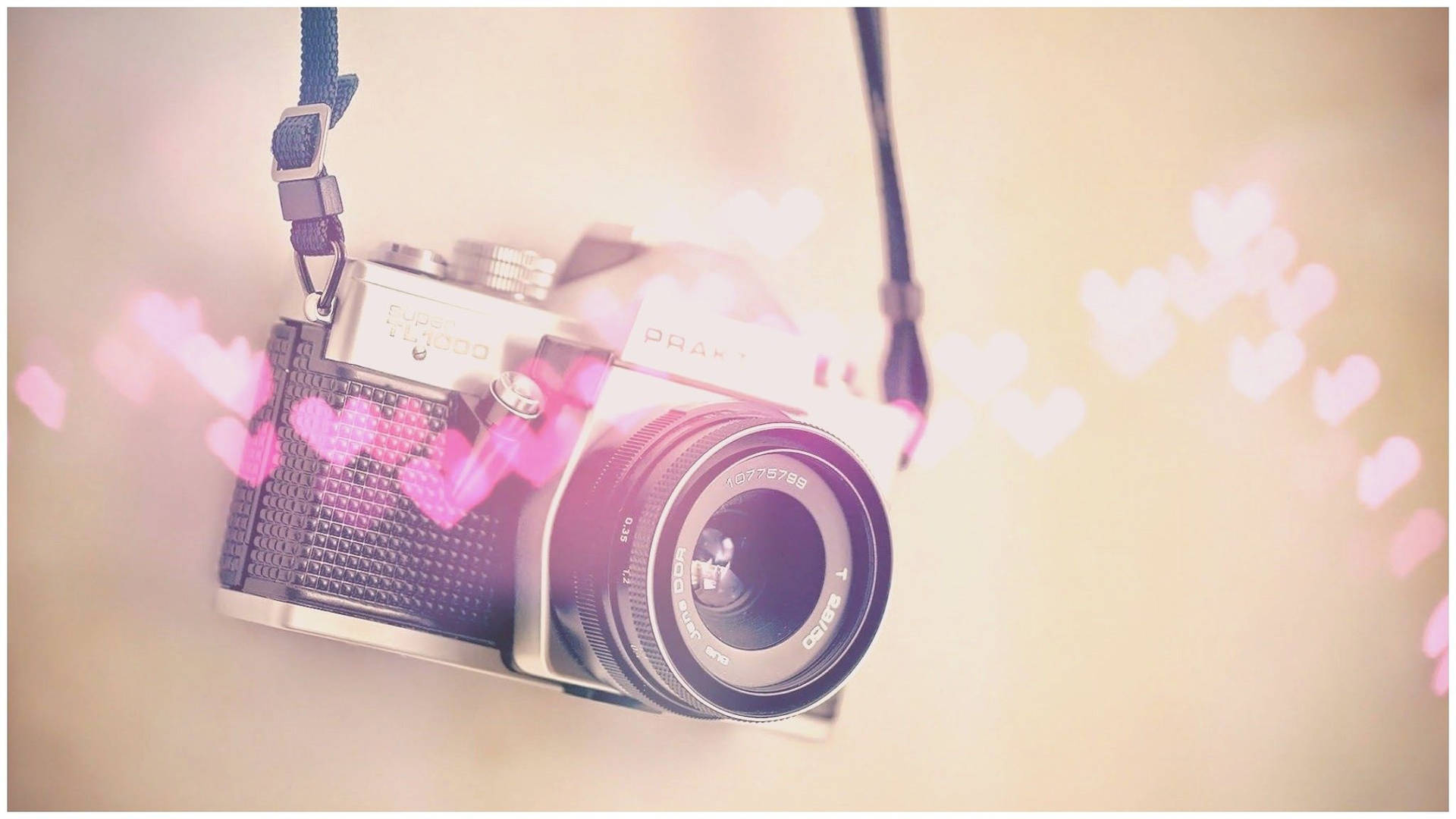 En kamera med hjerter, der hænger fra det. Wallpaper