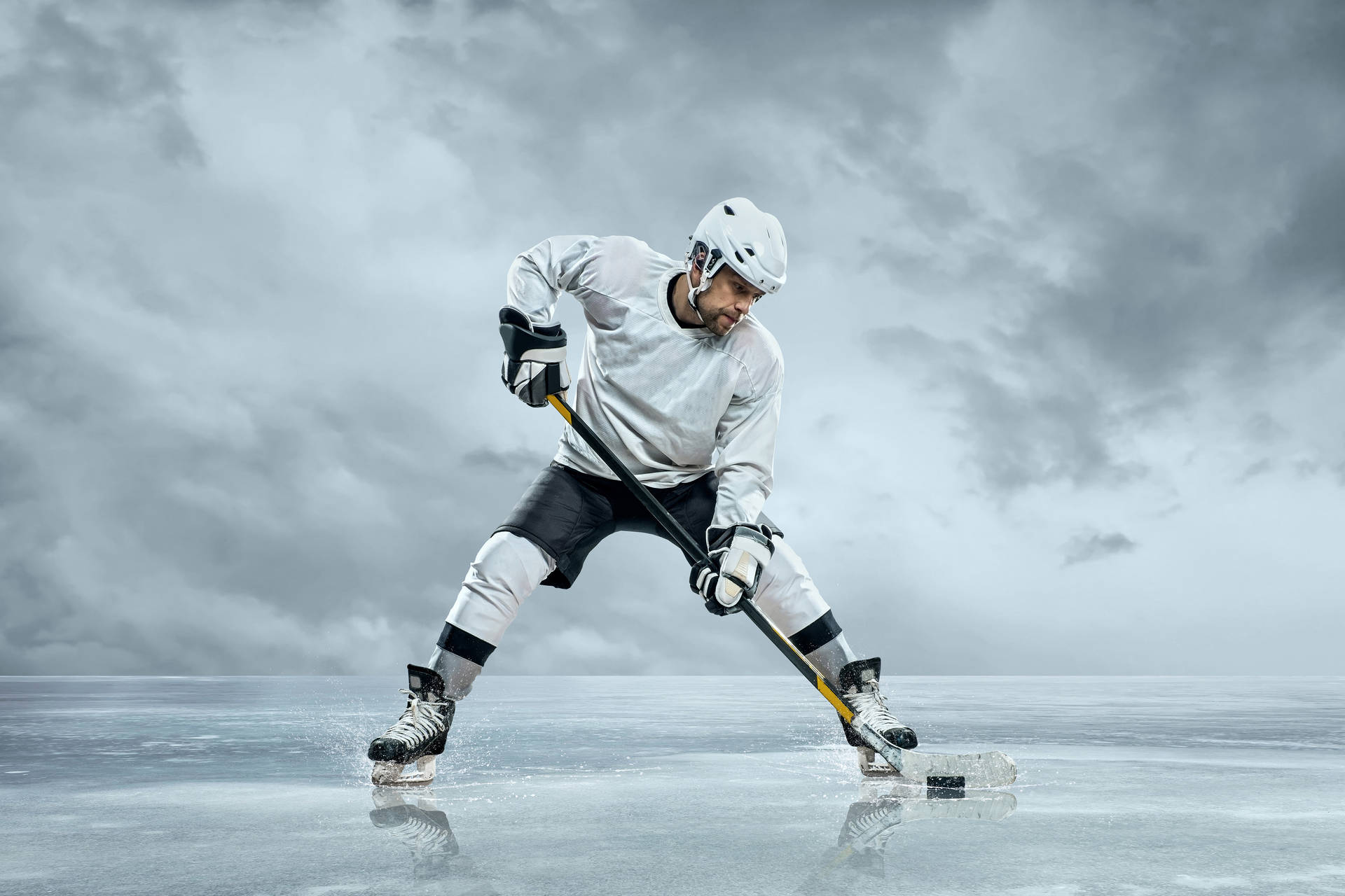 A Hockey Player Is Playing On Ice With A Cloudy Sky Wallpaper