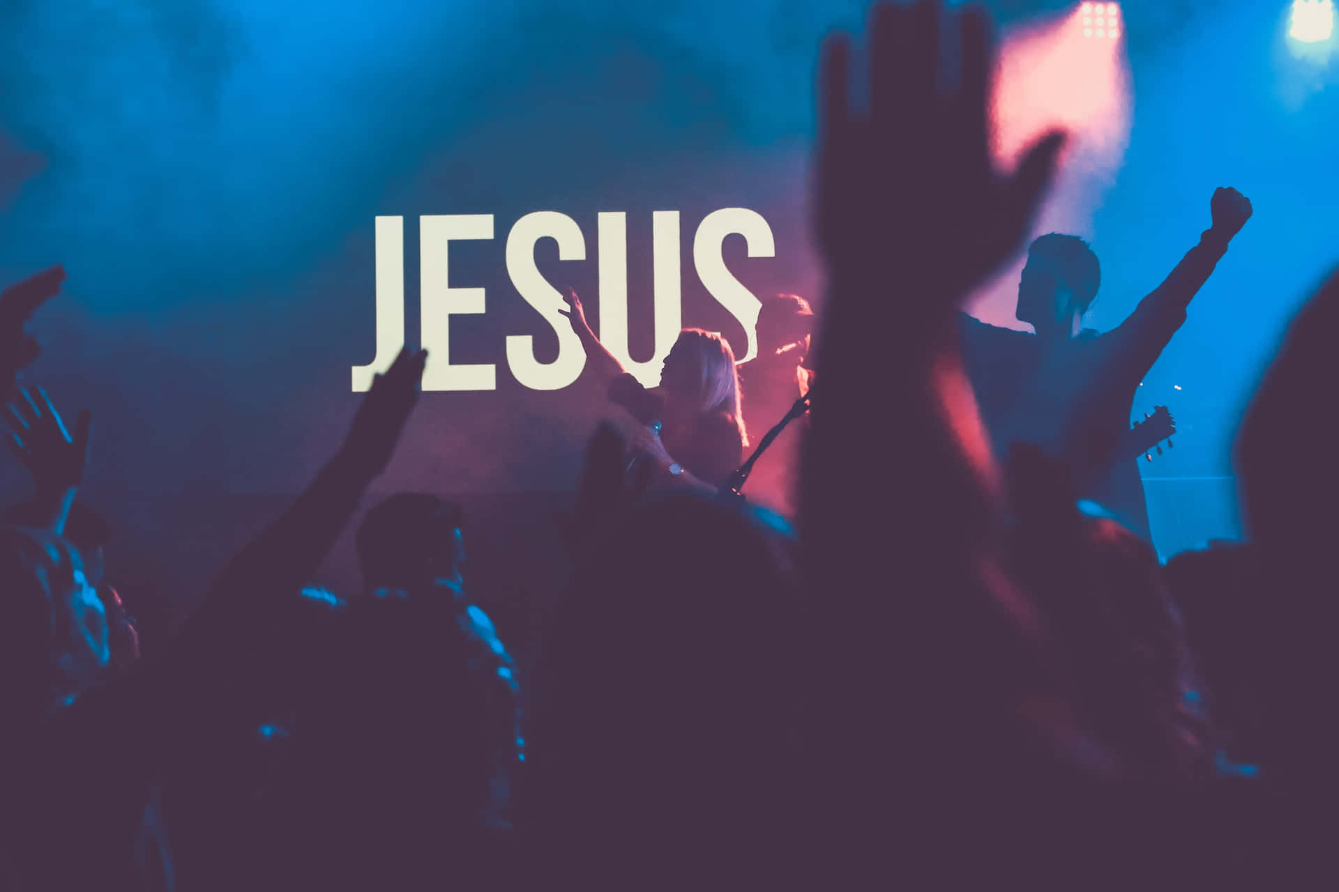 A Crowd Of People At A Concert With The Word Jesus Wallpaper