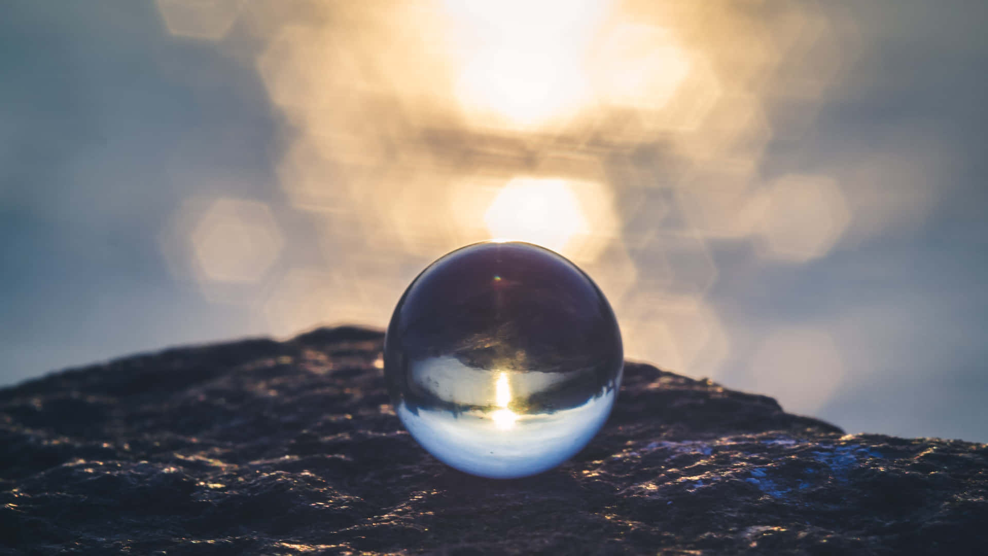 A Glass Ball Sitting On Top Of A Rock Wallpaper