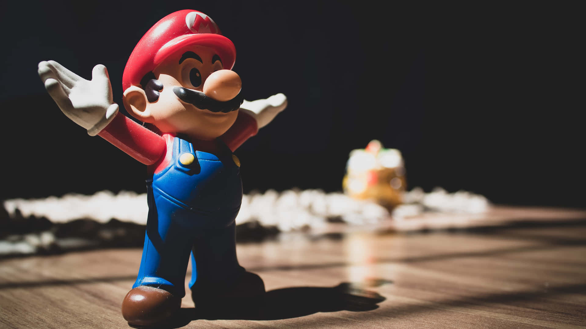 A Mario Figurine Is Standing In Front Of A Table Wallpaper