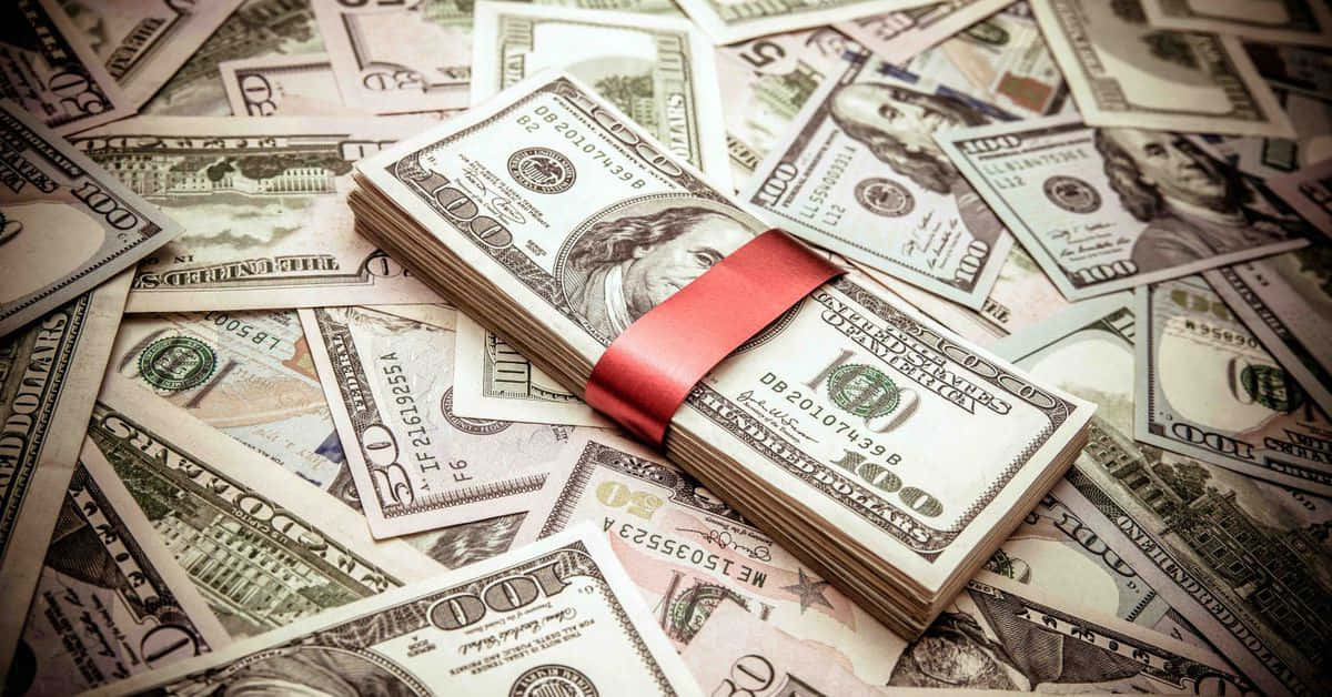 A Red Ribbon Is Tied Around A Pile Of Money Wallpaper