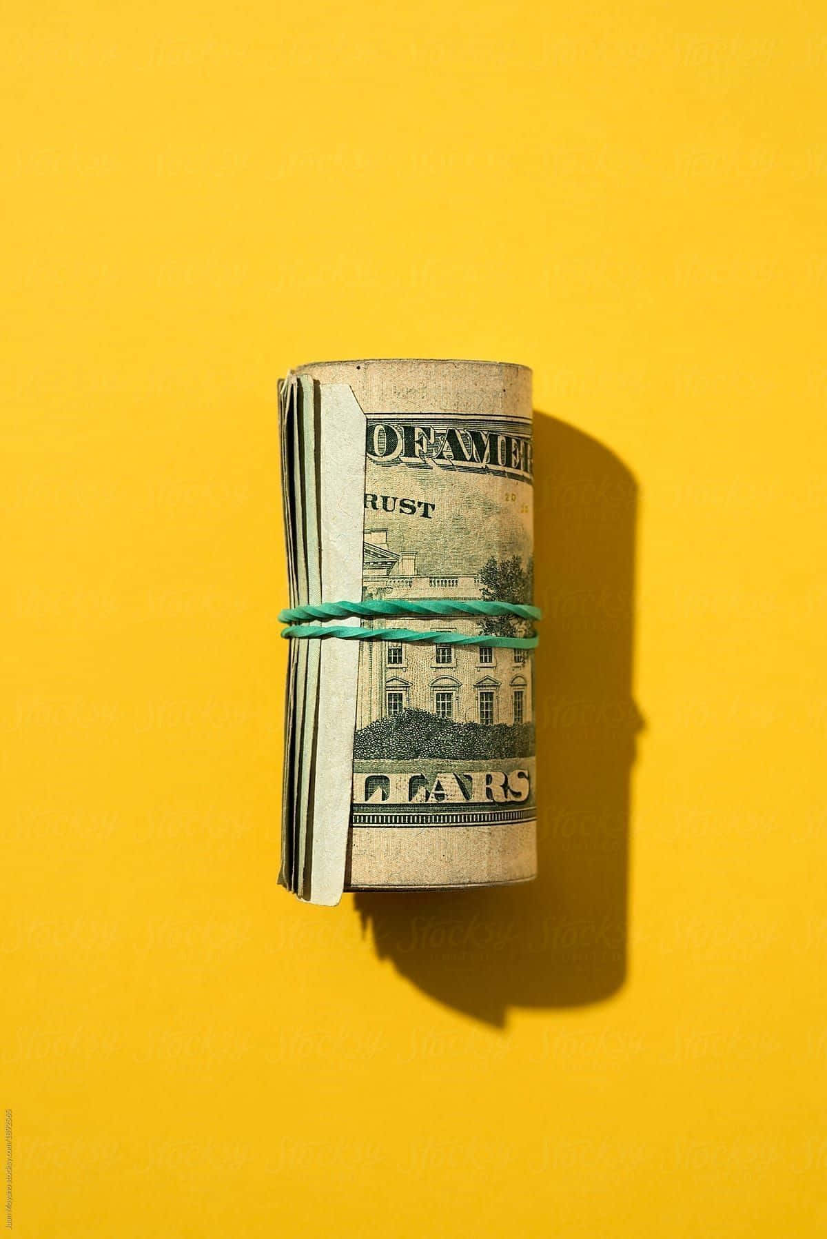En stak af dollar sedler på en gul baggrund af Samantha McDonald for Stocksy United. Wallpaper