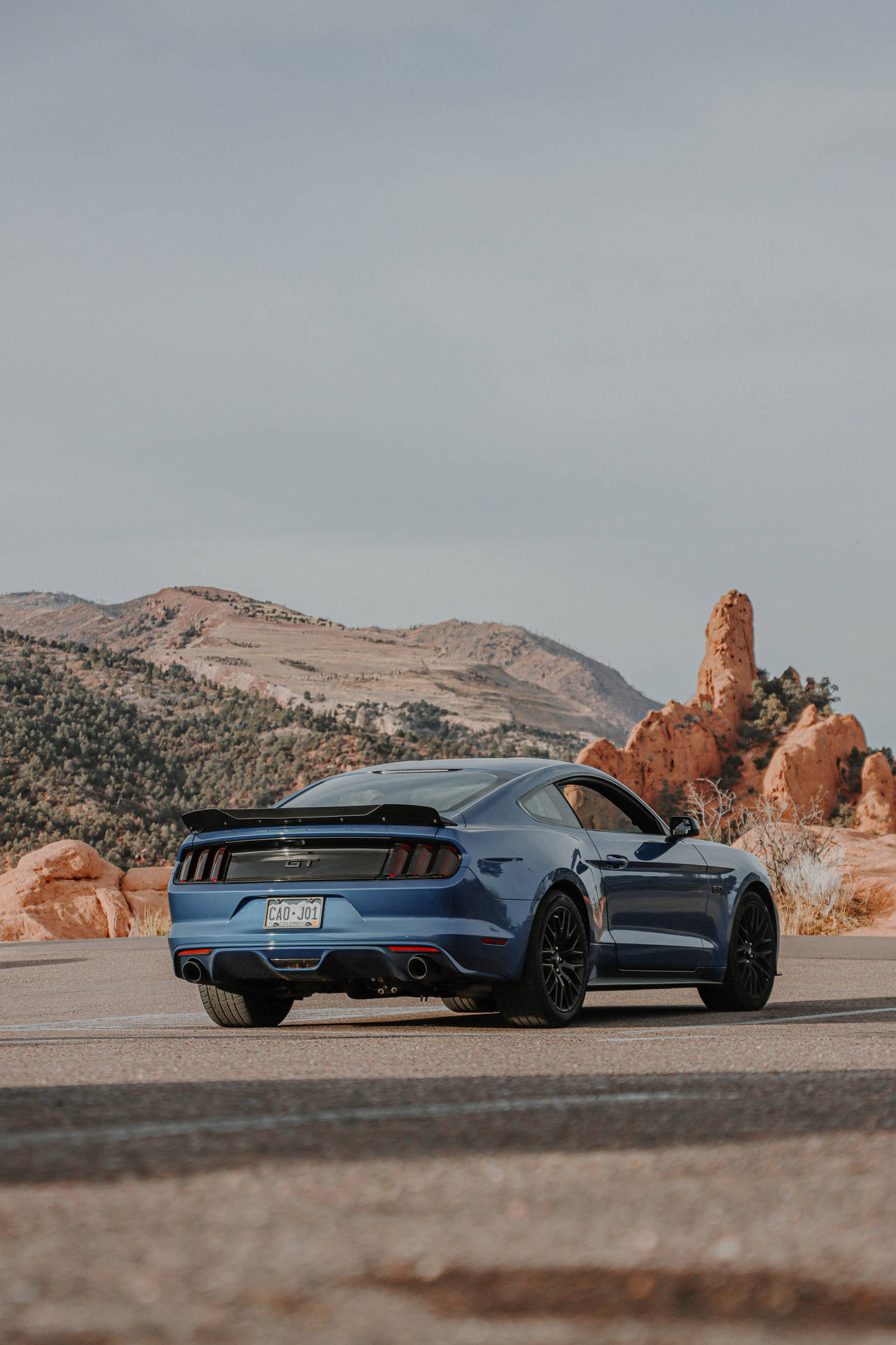 A Blue Ford Mustang Gt Parked In The Desert Wallpaper